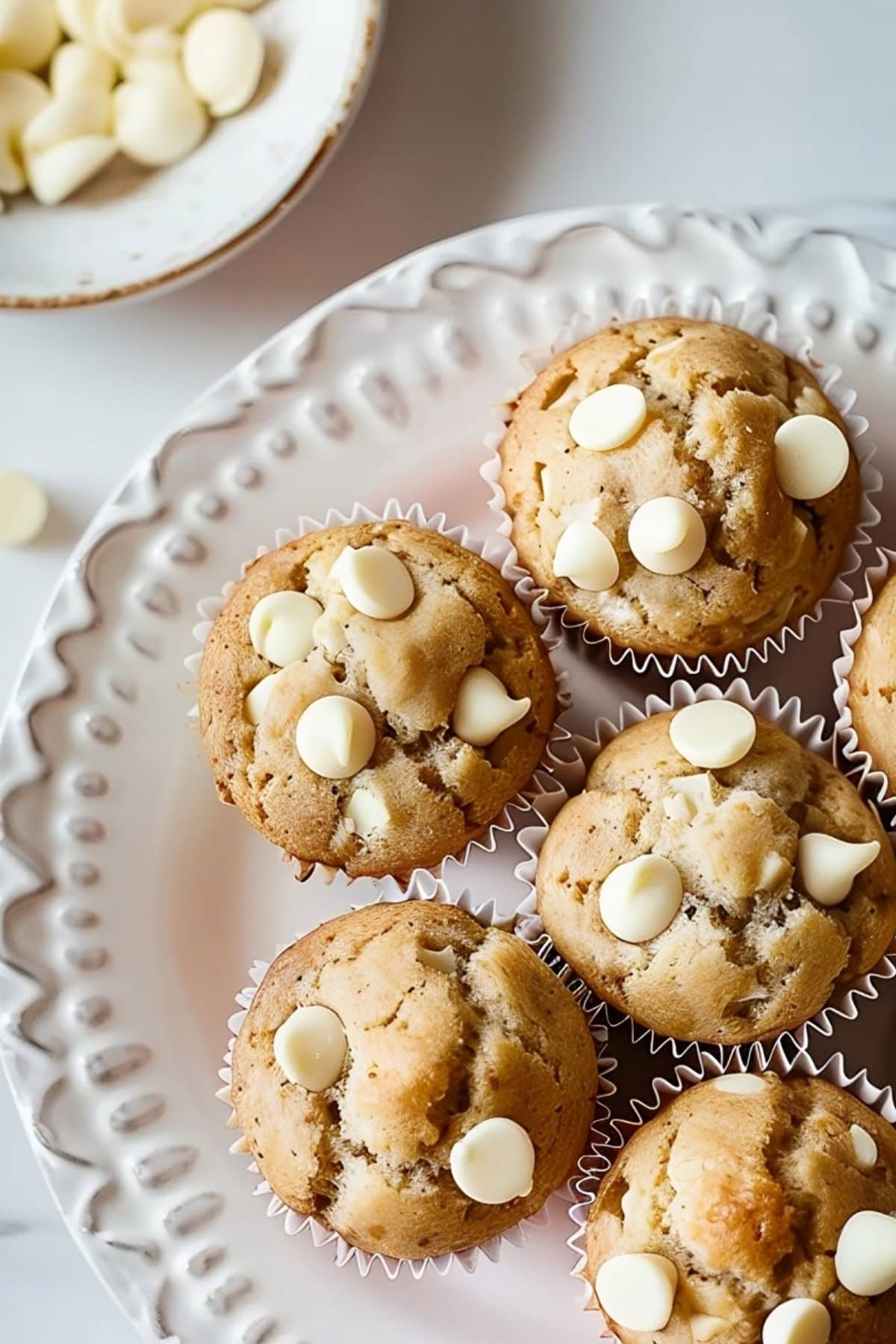 Top view of White Chocolate Chip Muffins Arranged on a White Plate