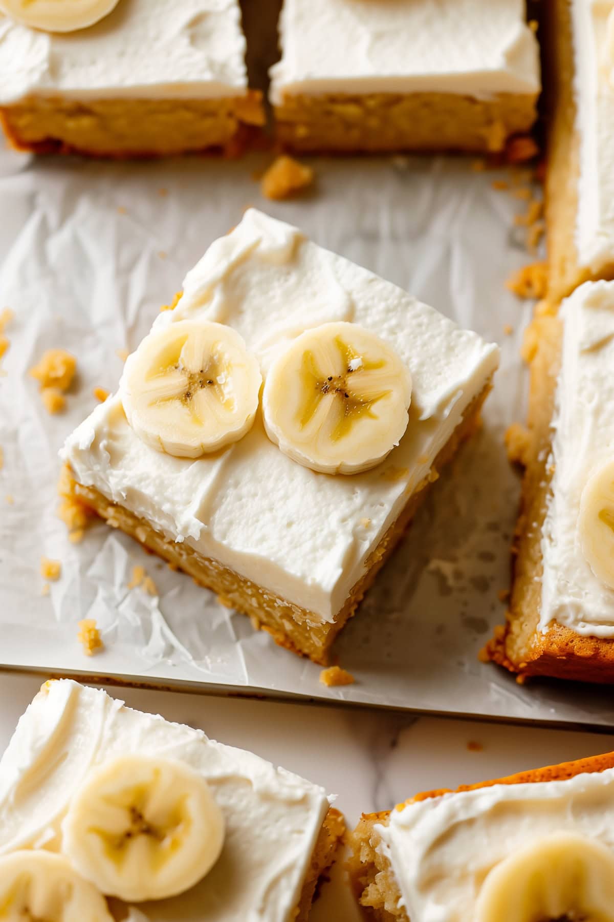 Classic banana cake with frosting and banana slices, top down view