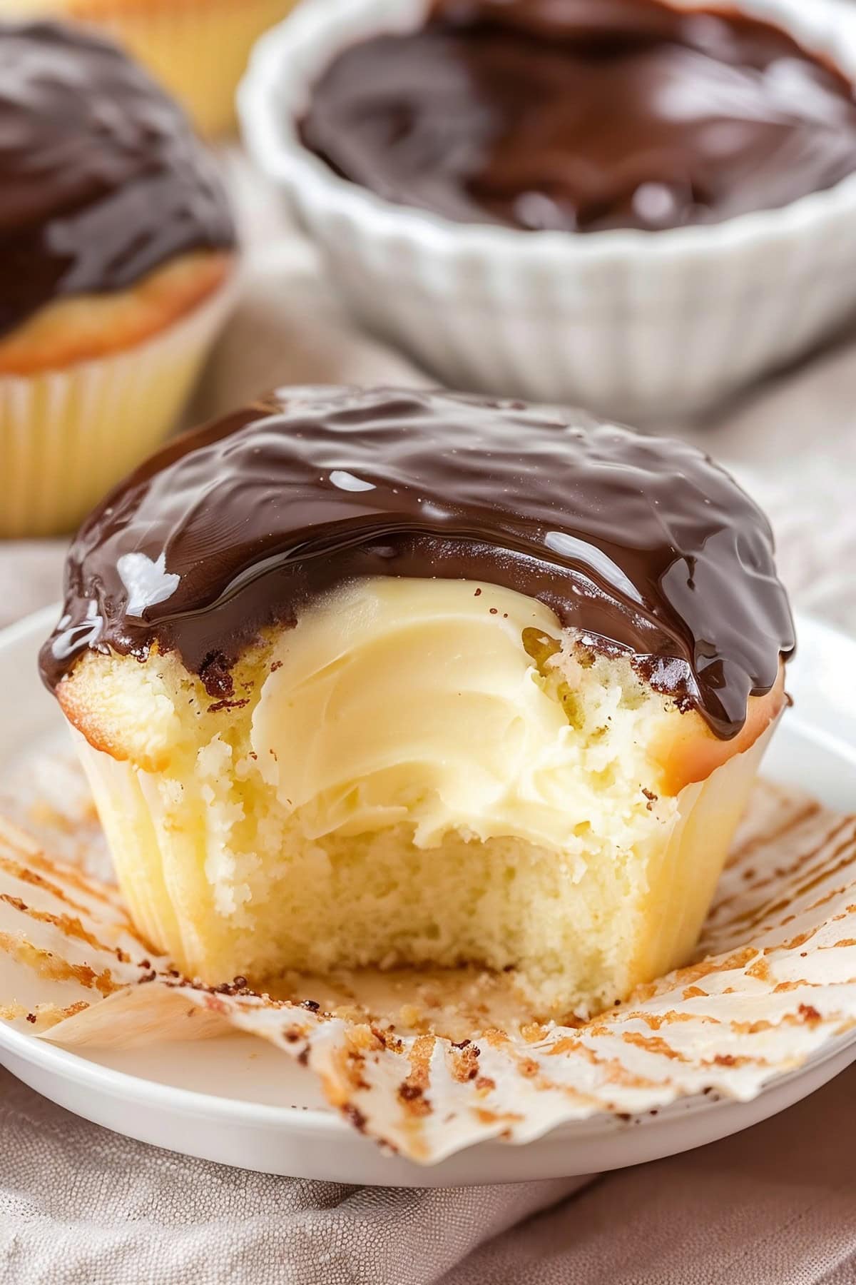 Fluffy vanilla cupcake with cream cheese filling covered with chocolate ganache.