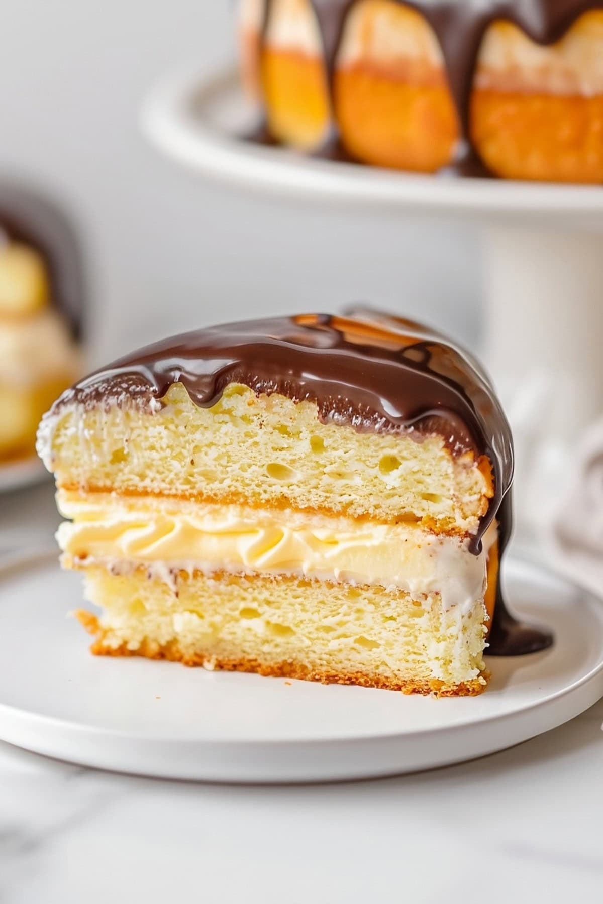 A slice of Boston cream pie in a white plate.