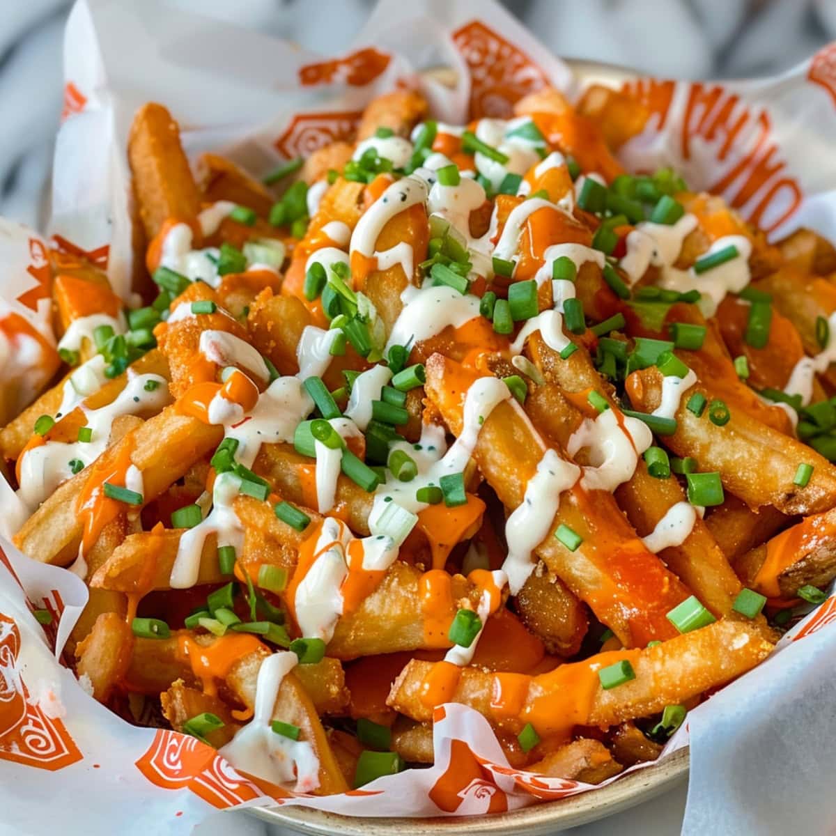 Golden fries with a generous coating of buffalo sauce, ranch dressing, and chopped chives