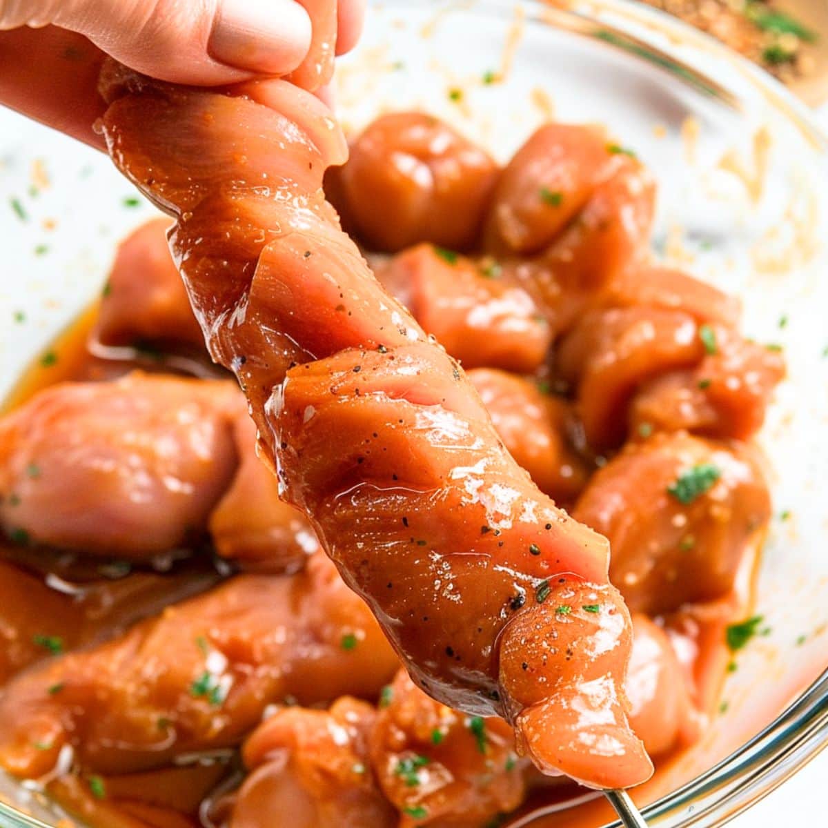 Marinated chicken thread on a metal skewer.