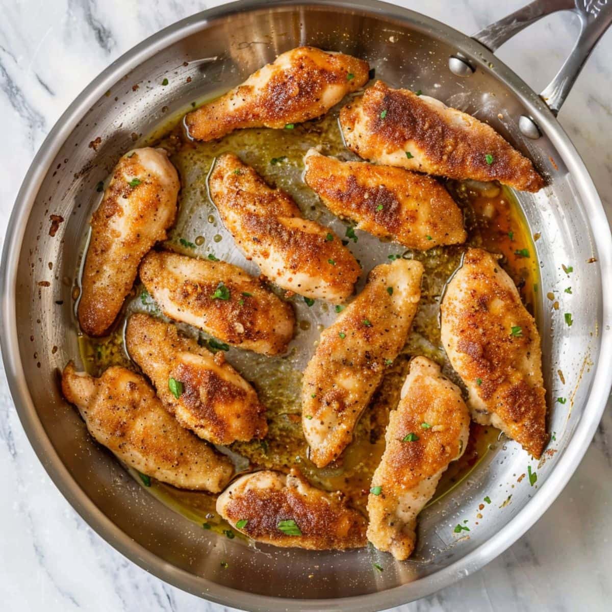 Chicken tenders cooked in skillet.