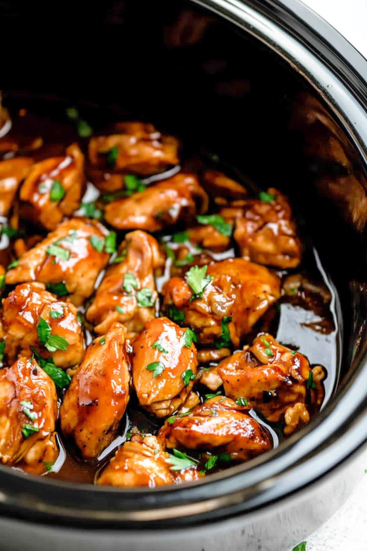 Chicken thigh with sauce made with bourbon, soy sauce, brown sugar, ketchup, vinegar, honey, garlic, ginger, and red pepper flakes cooked in a slow cooker. 