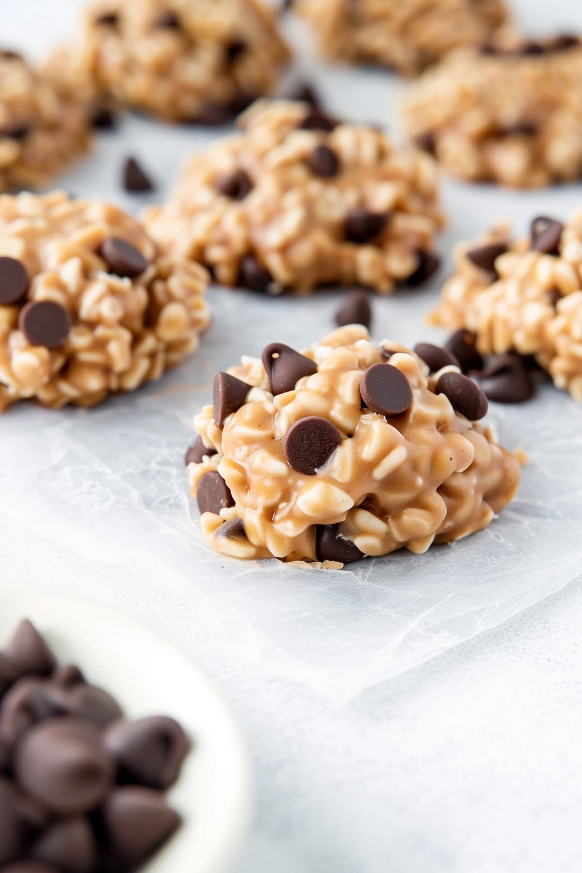 Easy no-bake avalanche cookies with crispy rice cereal and marshmallows, topped with chocolate chips on parchment paper