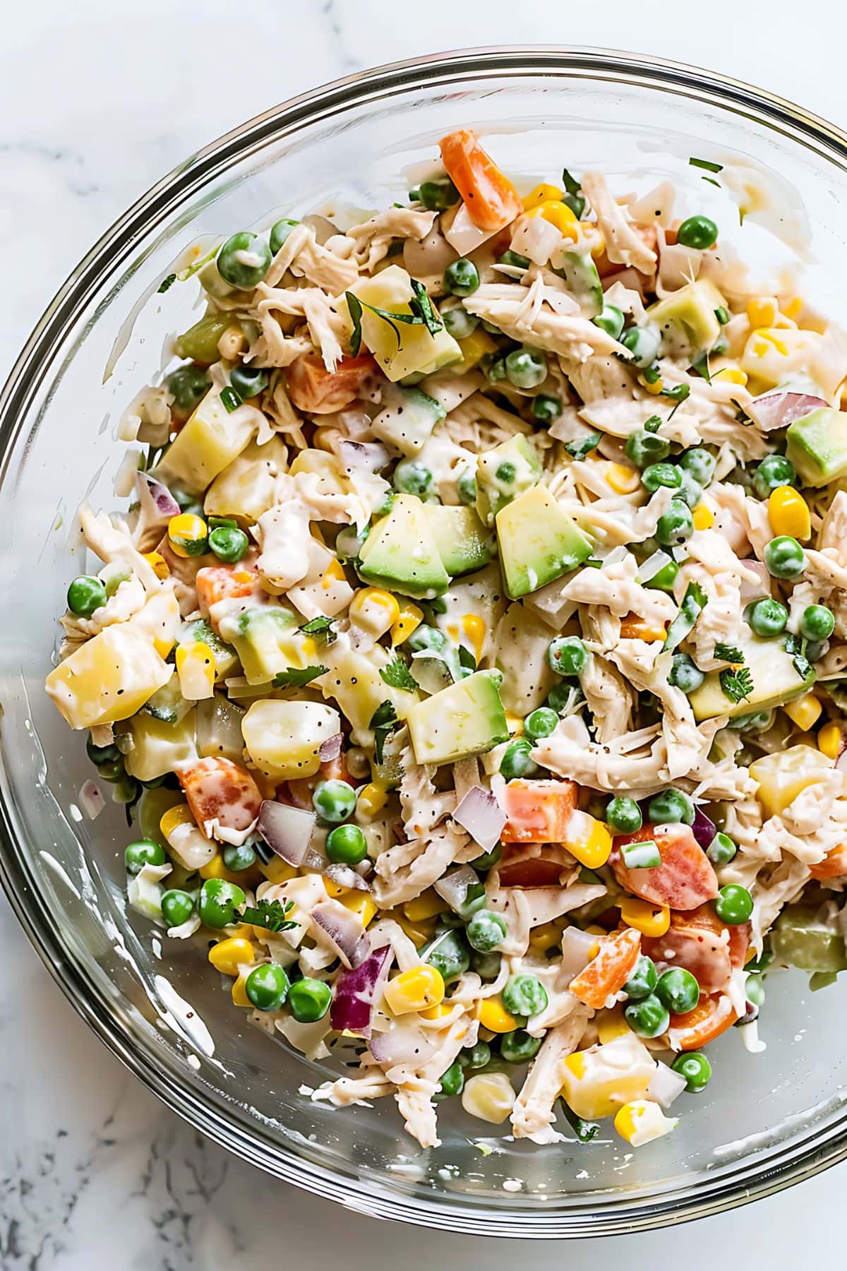 Glass mixing bowl filled with creamy Mexican chicken salad, top view