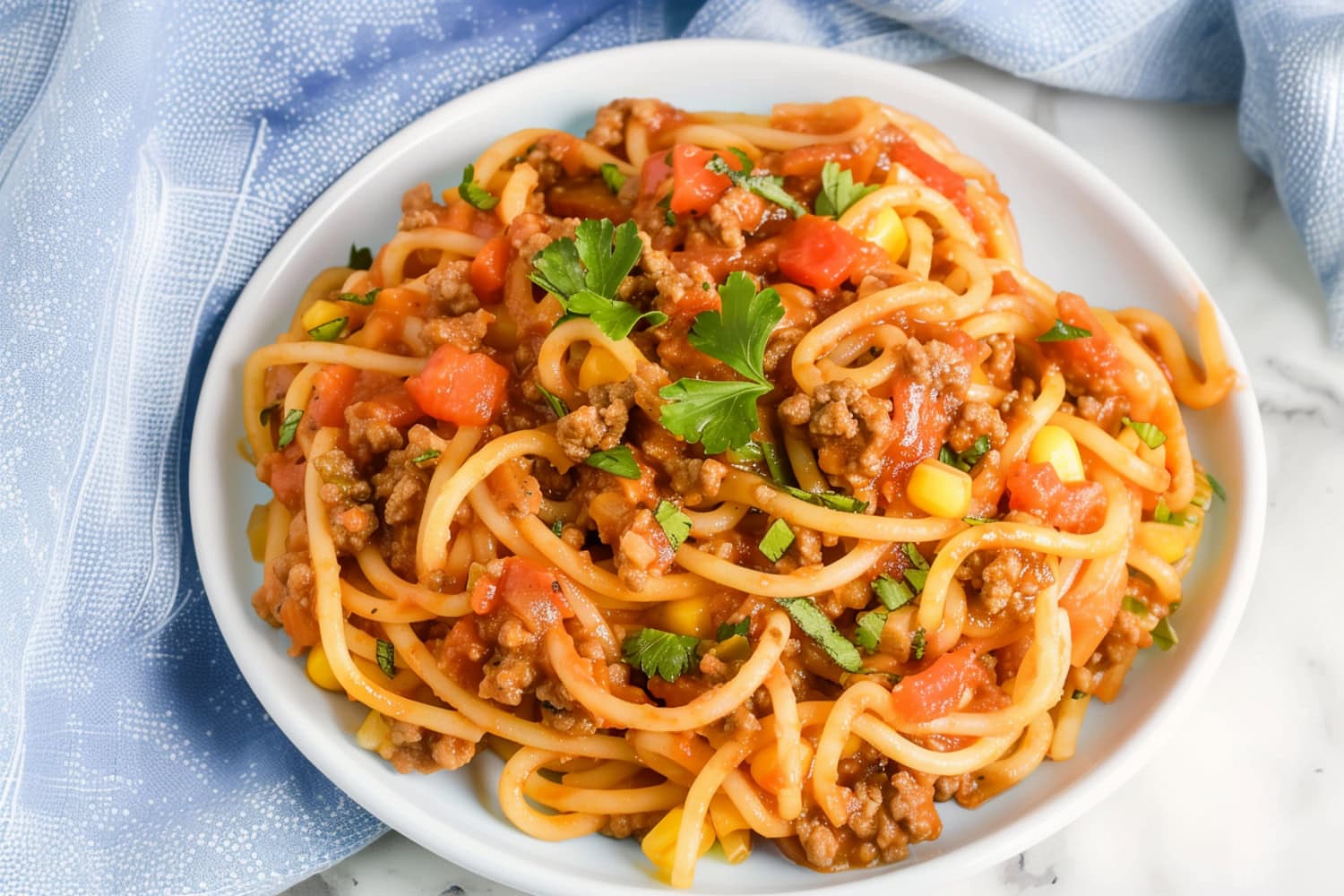 Homemade Mexican spaghetti Vibrant Mexican spaghetti, topped with diced tomatoes and fresh cilantro.