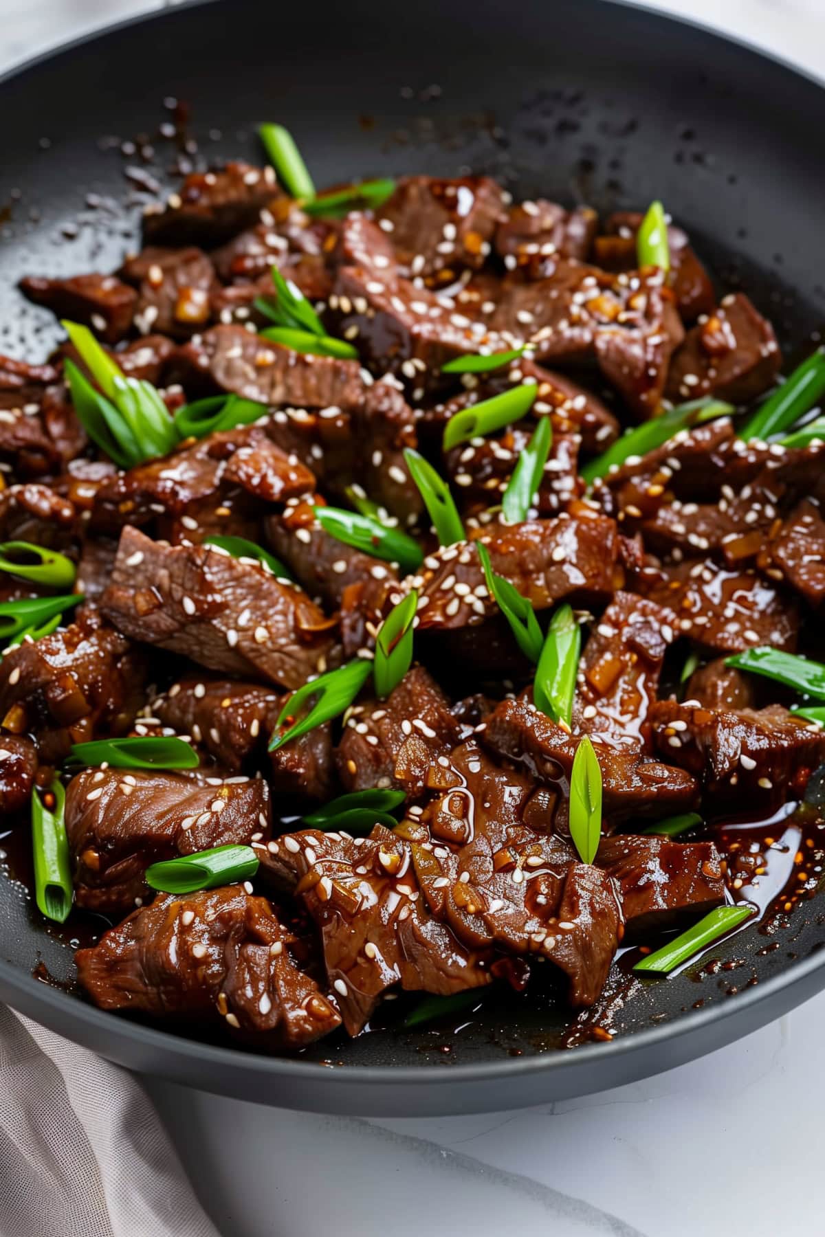 Classic Mongolian beef with a rich, sticky sauce and scallions as garnish.