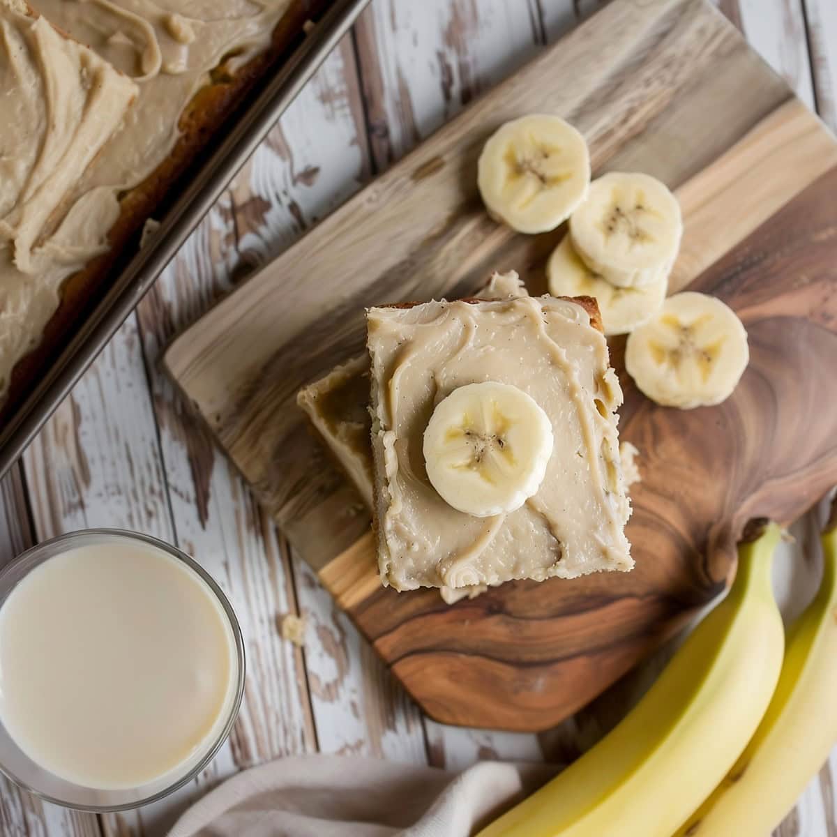 Banana bread with brown butter frosting slice on a wooden chopping board.