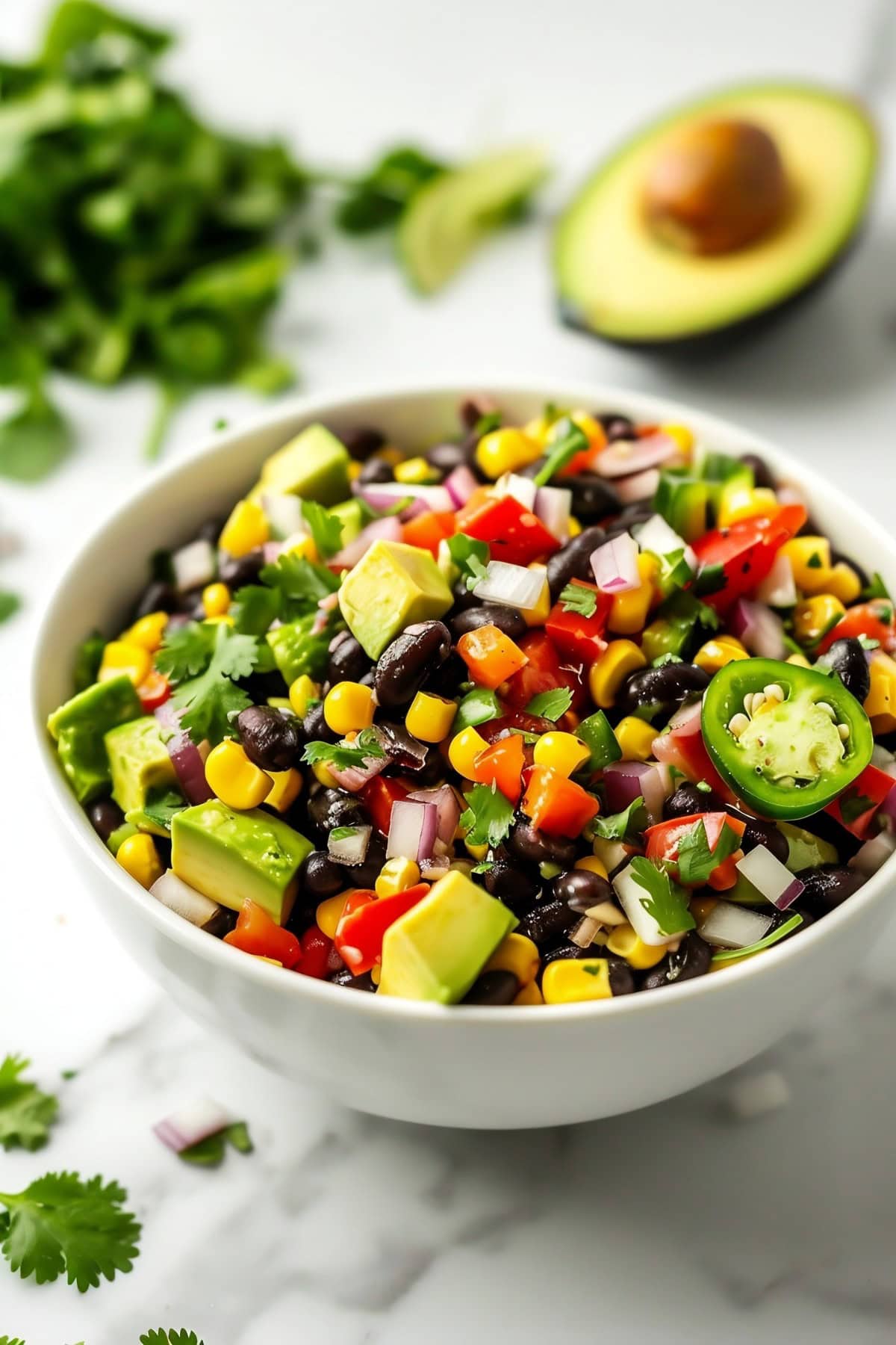 Black Bean and Corn Salad with Avocados and Red Onions in a White Bowl