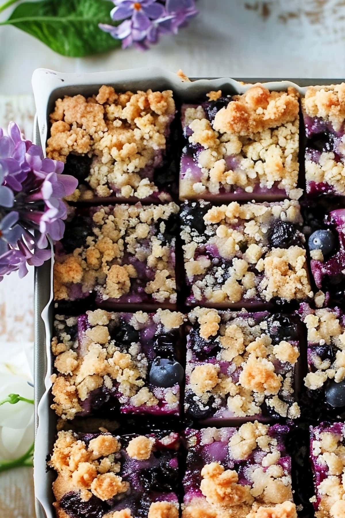 Delicious blueberry bars with crumbled topping in a baking dish, top view.