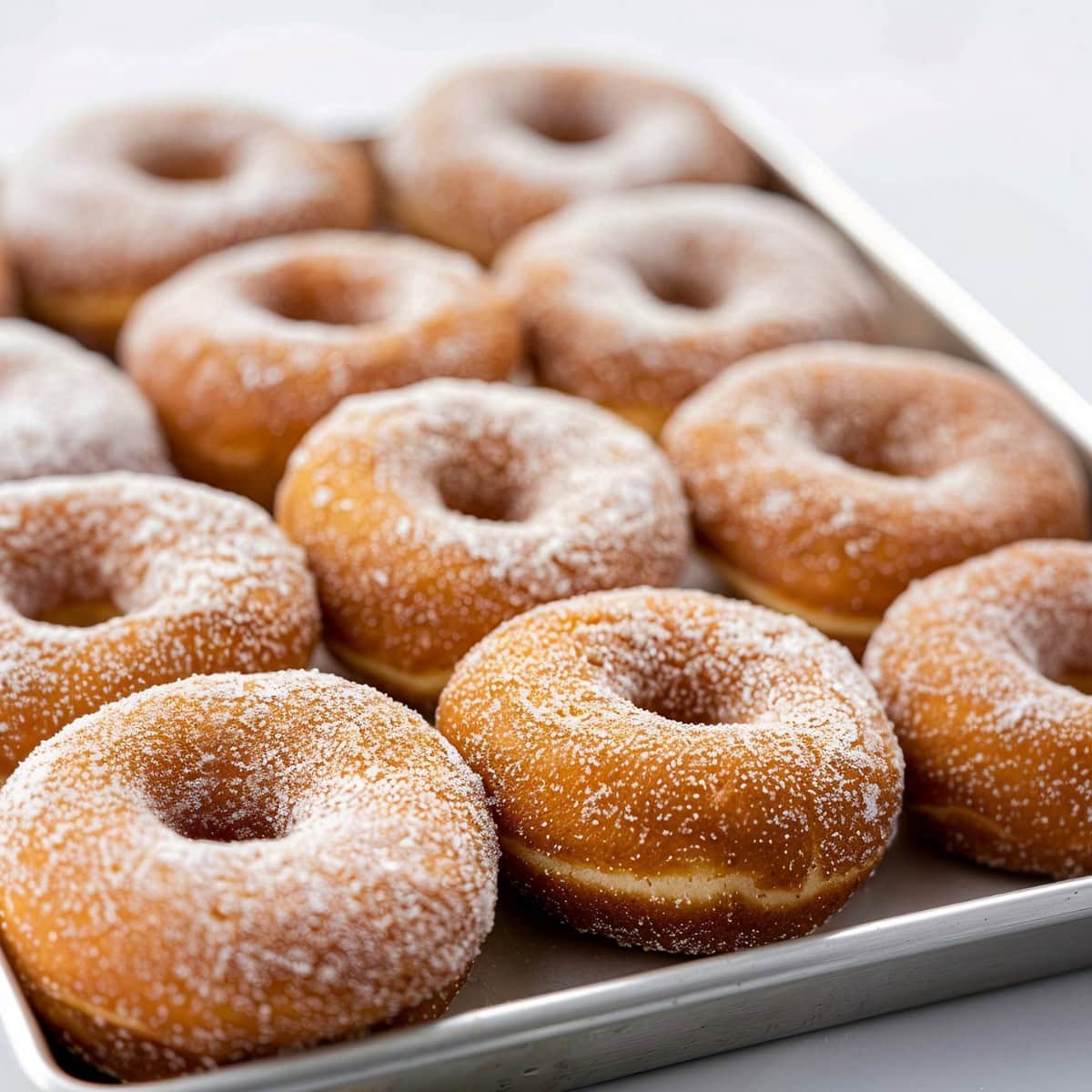 Cinnamon sugar donuts on a baking pan