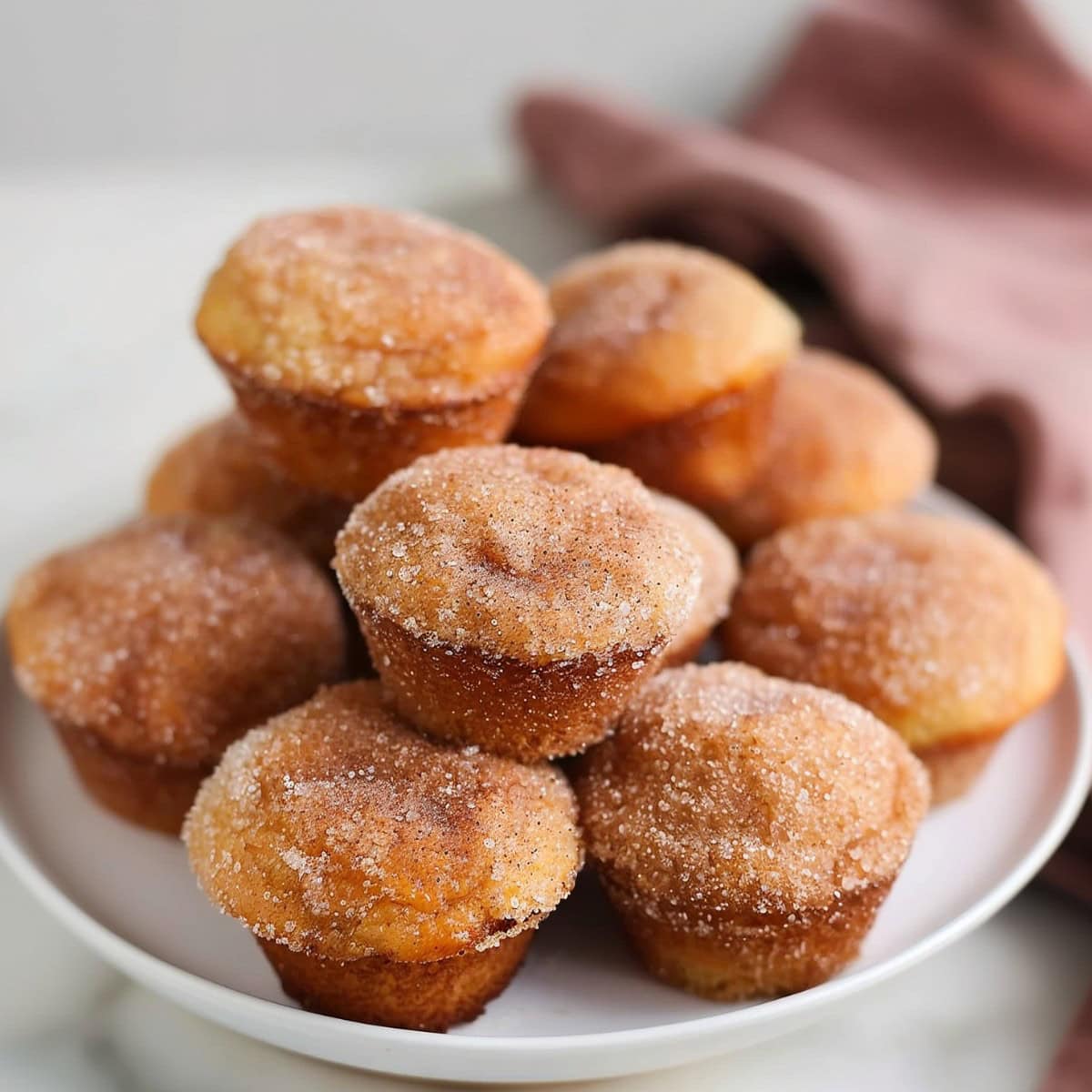 A plate full of cinnamon sugar donut muffins 