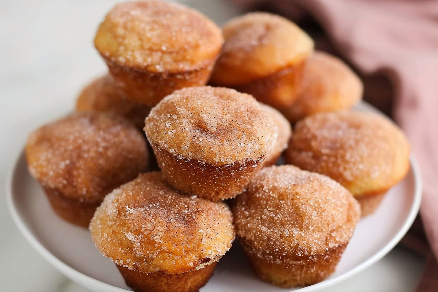 Bunch of donut muffins in a white plate.