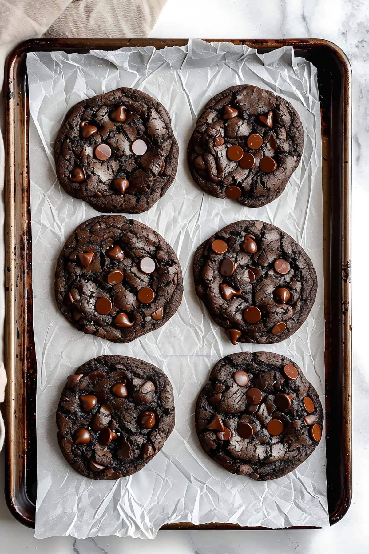 Double Chocolate Chip Cookies in a baking pan with parchment  paper, top down view