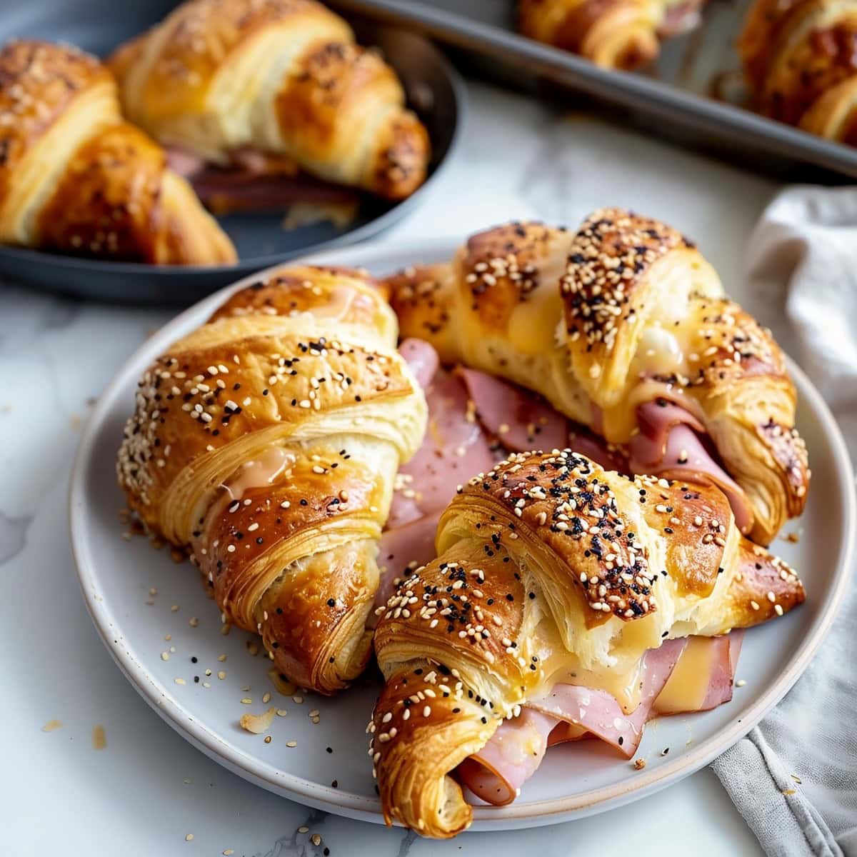 Freshly baked ham and cheese croissant with a golden, flaky crust and melted cheese.