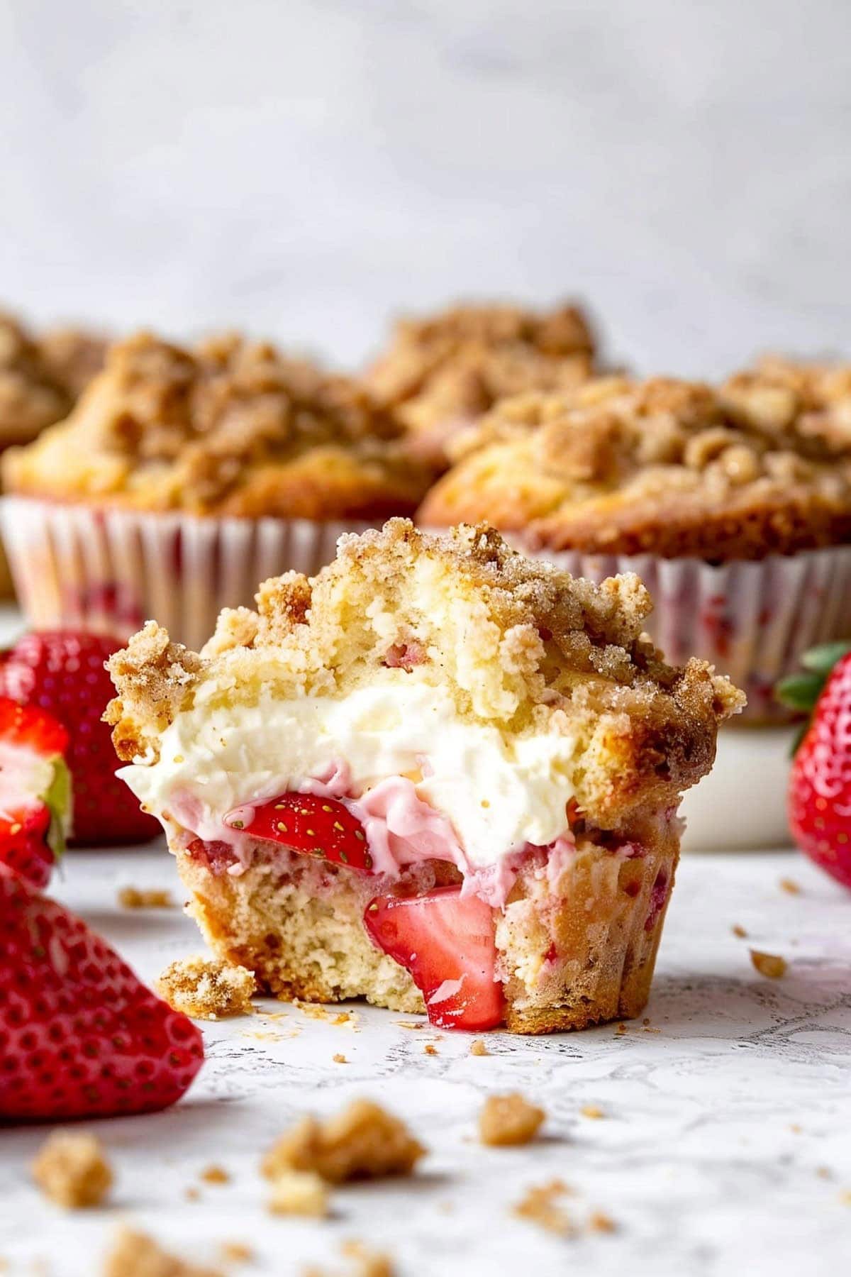 Strawberry cheesecake muffin cut in half to show creamy filling