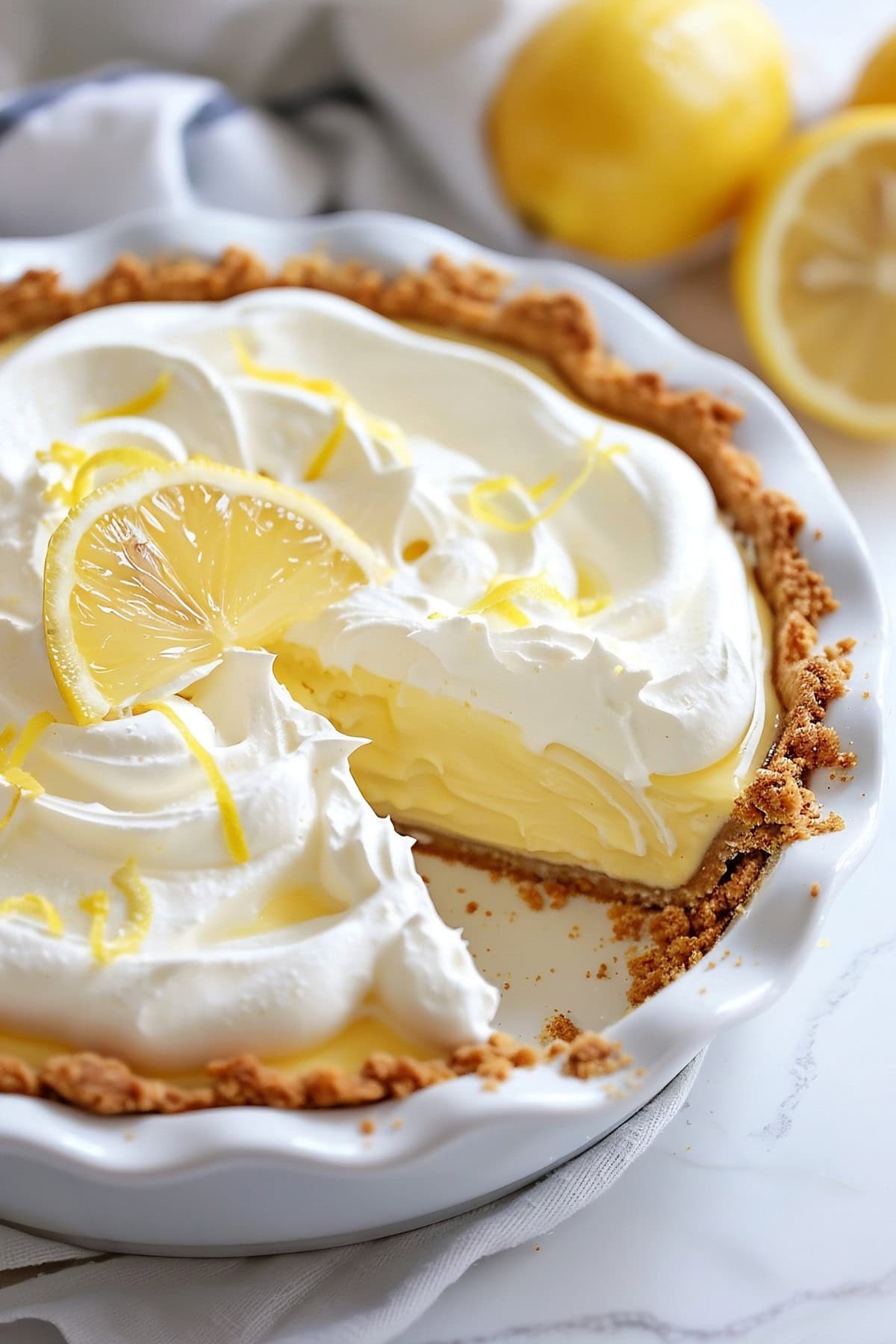 Slice missing Lemon Cream Pie in a pie dish.