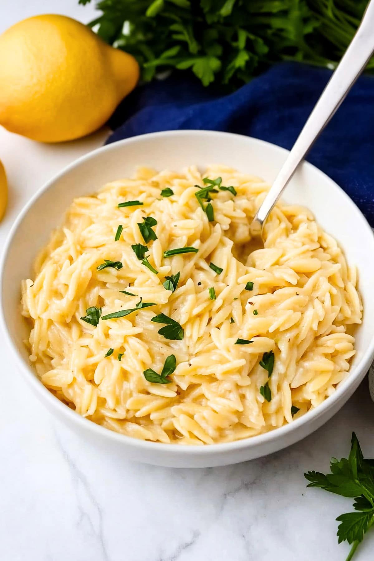 Healthy lemon orzo with herbs in a white bowl