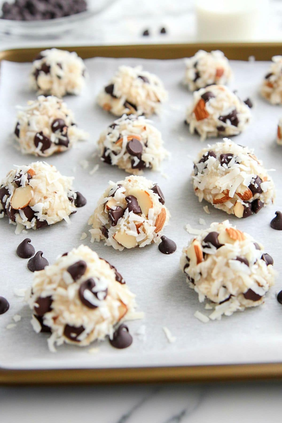 Almond joy cookie dough arranged in a baking pan with baking sheet.