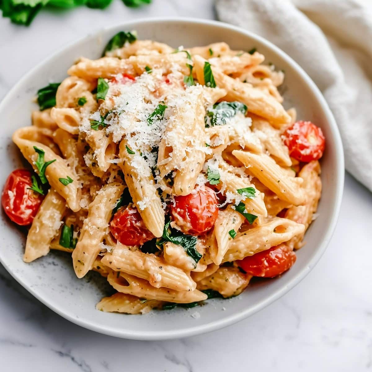 Rich and flavorful Boursin cheese pasta topped with cherry tomatoes and basil.