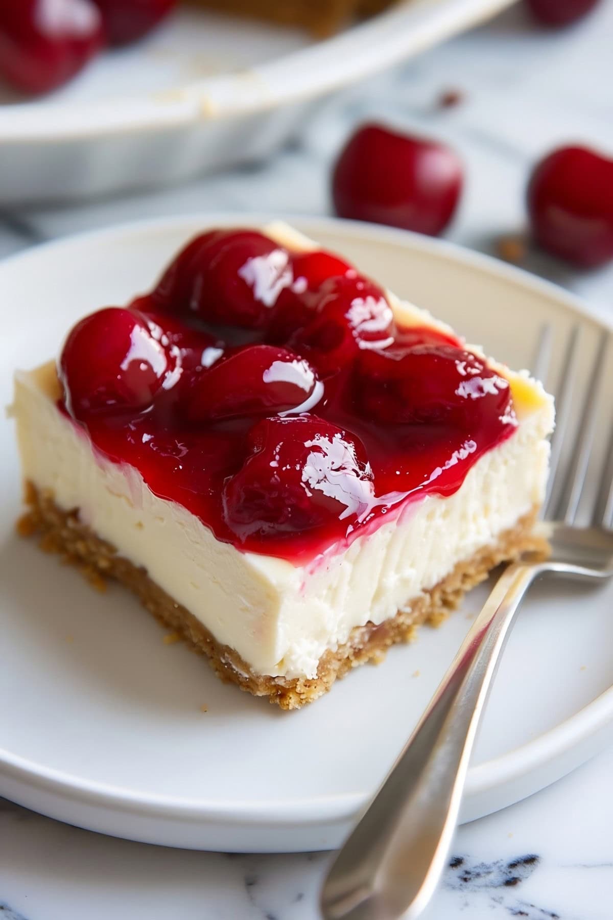 A piece of cheesecake bar topped with cherry sauce.