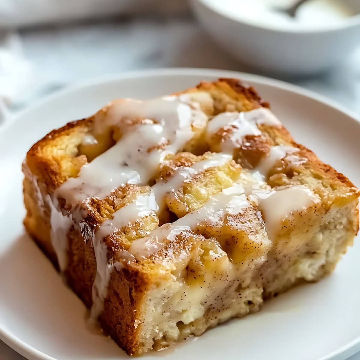 Slice of cinnamon roll with icing on top.