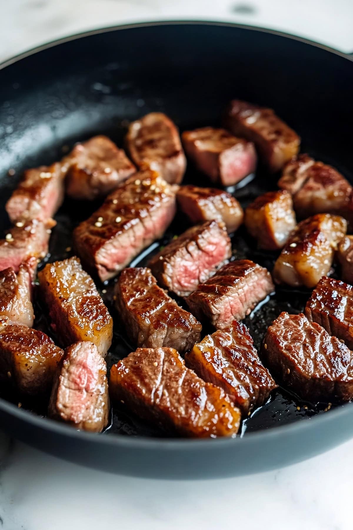 Homemade cooked sirloin steak in a black skillet.