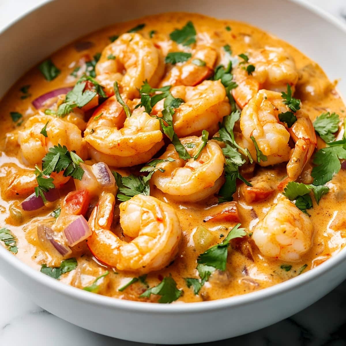 A serving of creamy chipotle shrimp served in a white bowl.