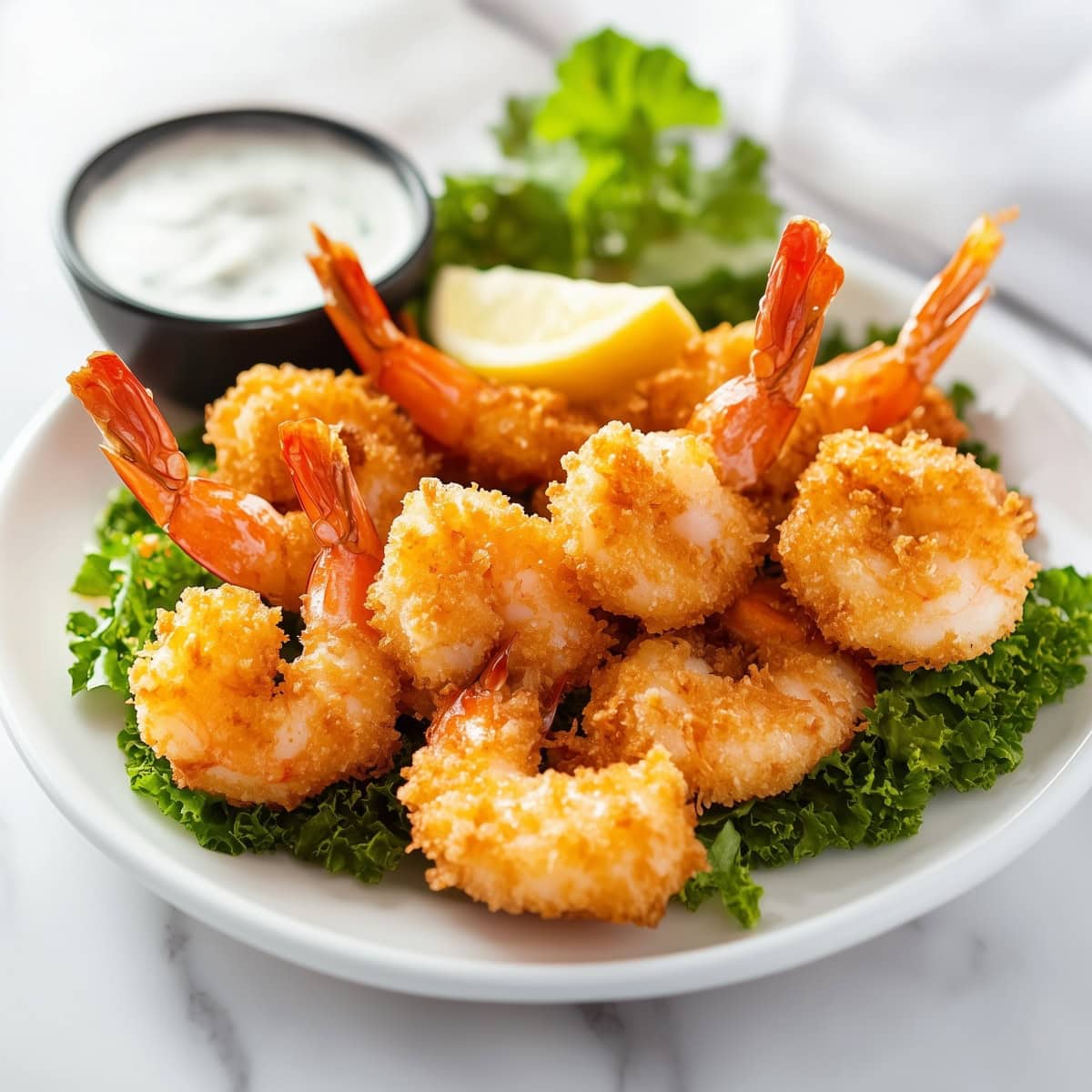 Coconut shrimp with panko crumbs served with lemon, lettuce, and dipping sauce.