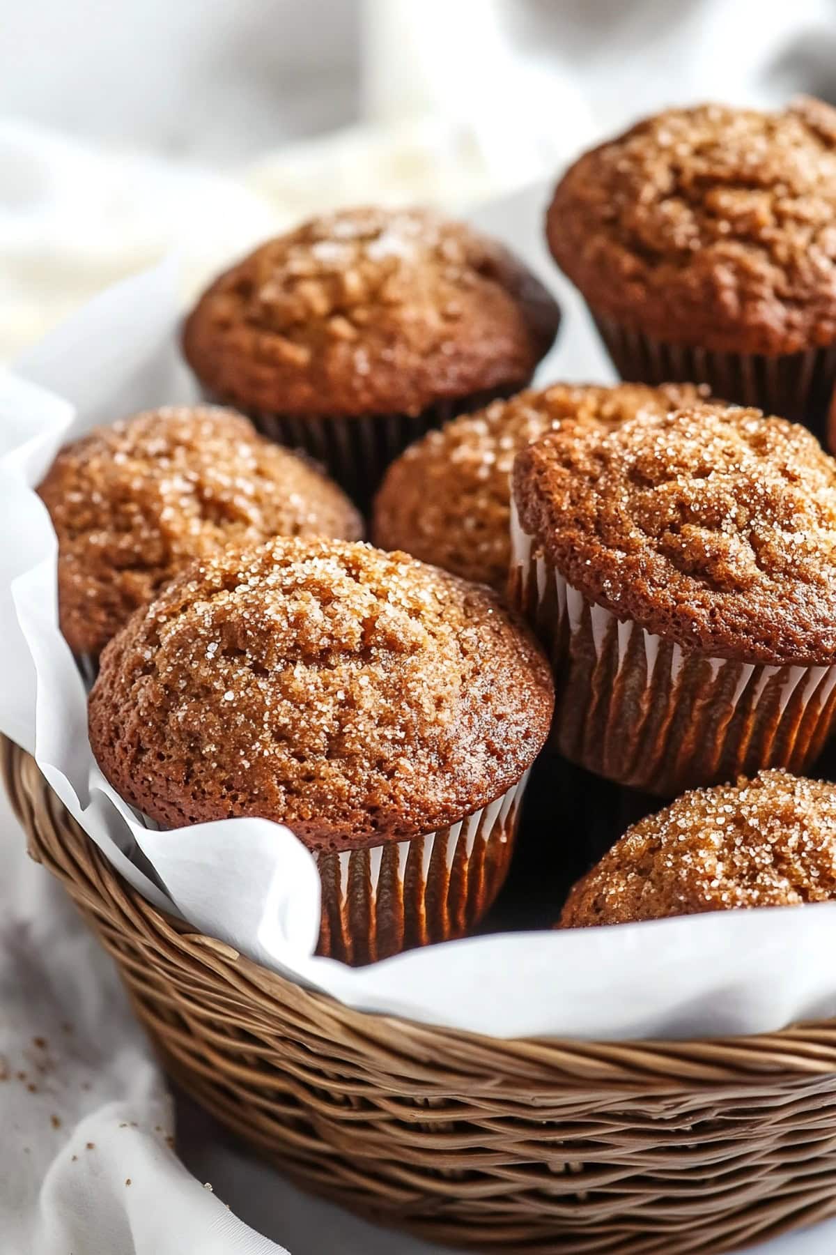 Warm gingerbread muffins with a dusting of sugar on top in a basket