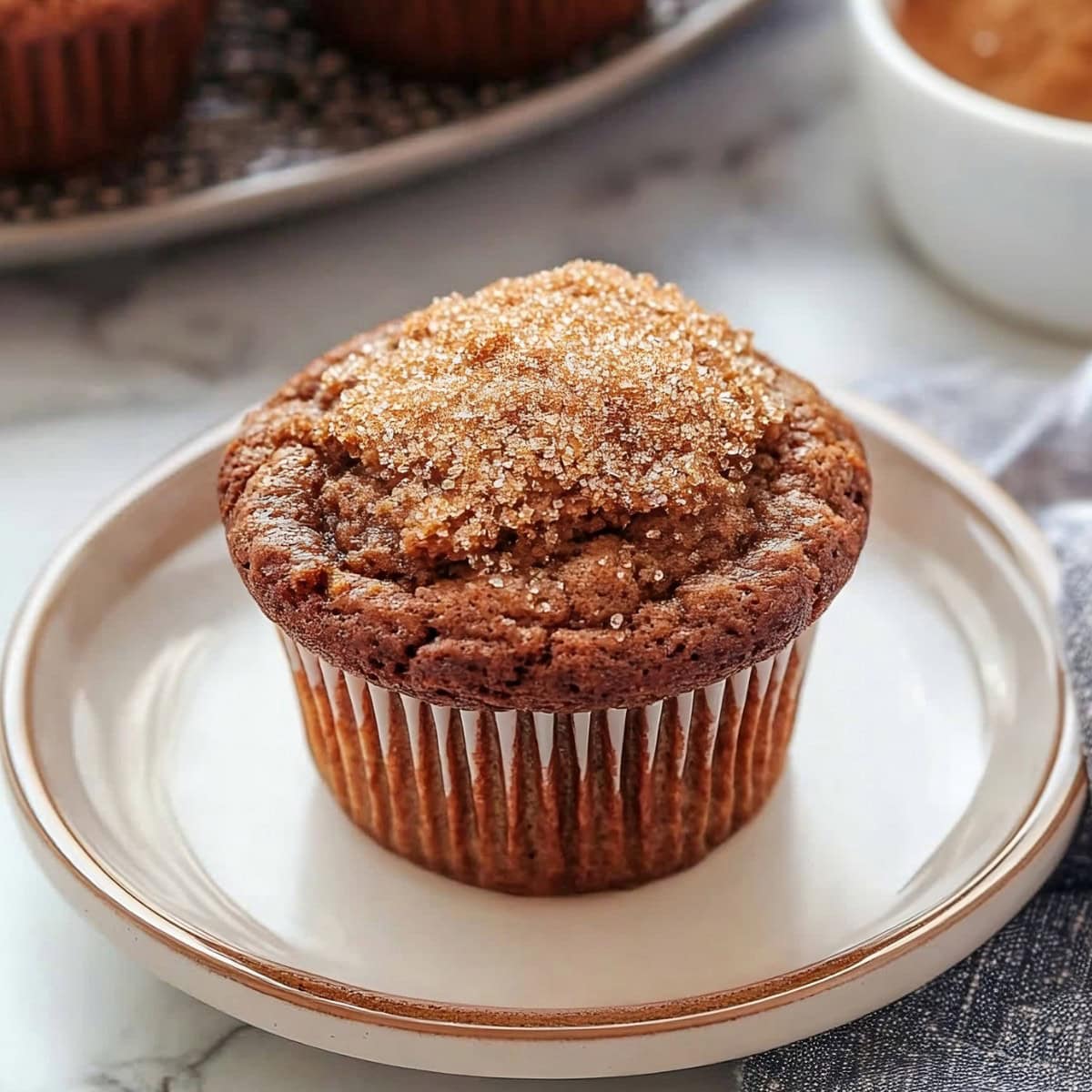 A freshly baked gingerbread muffin topped with sugar on a plate