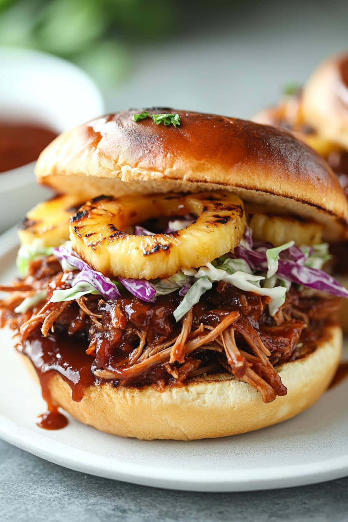 Pulled pork sandwich with grilled pineapples and brioche buns.