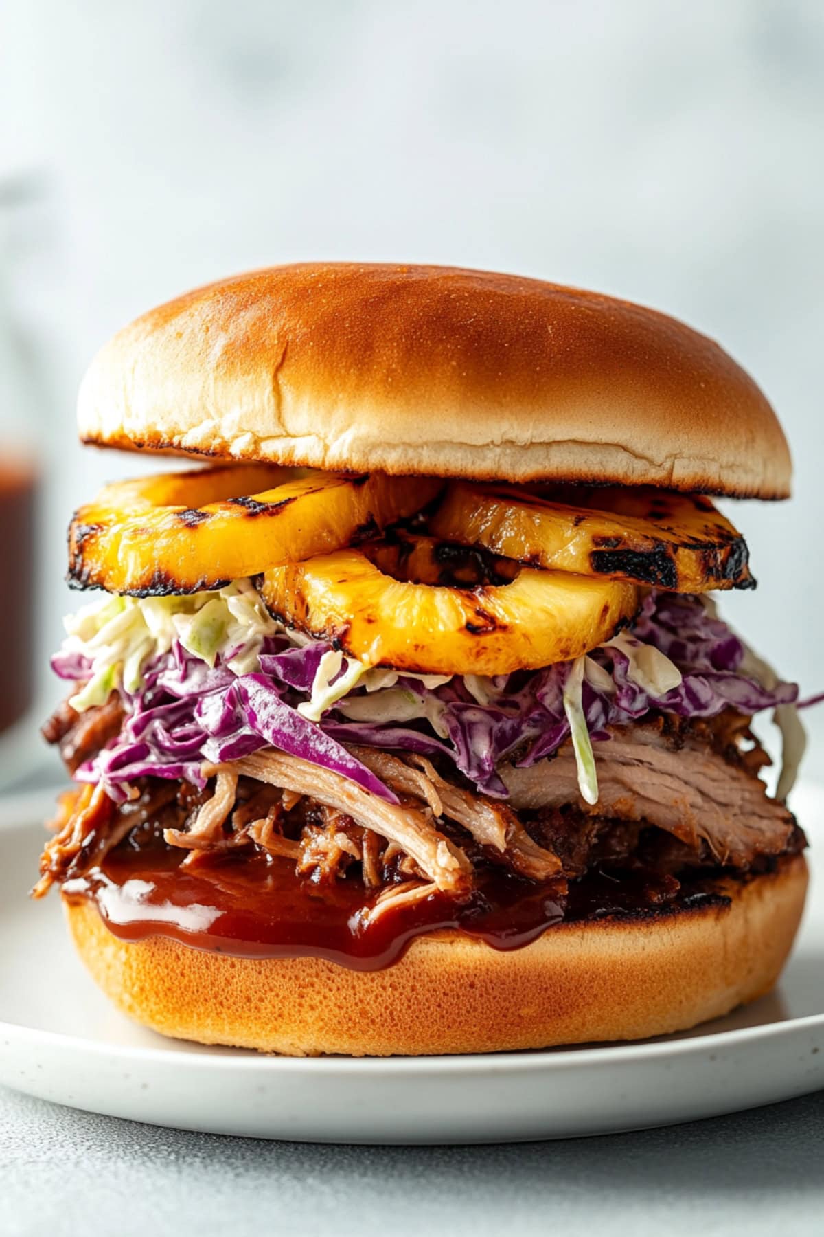 Juicy pulled pork sandwich served on a white plate.