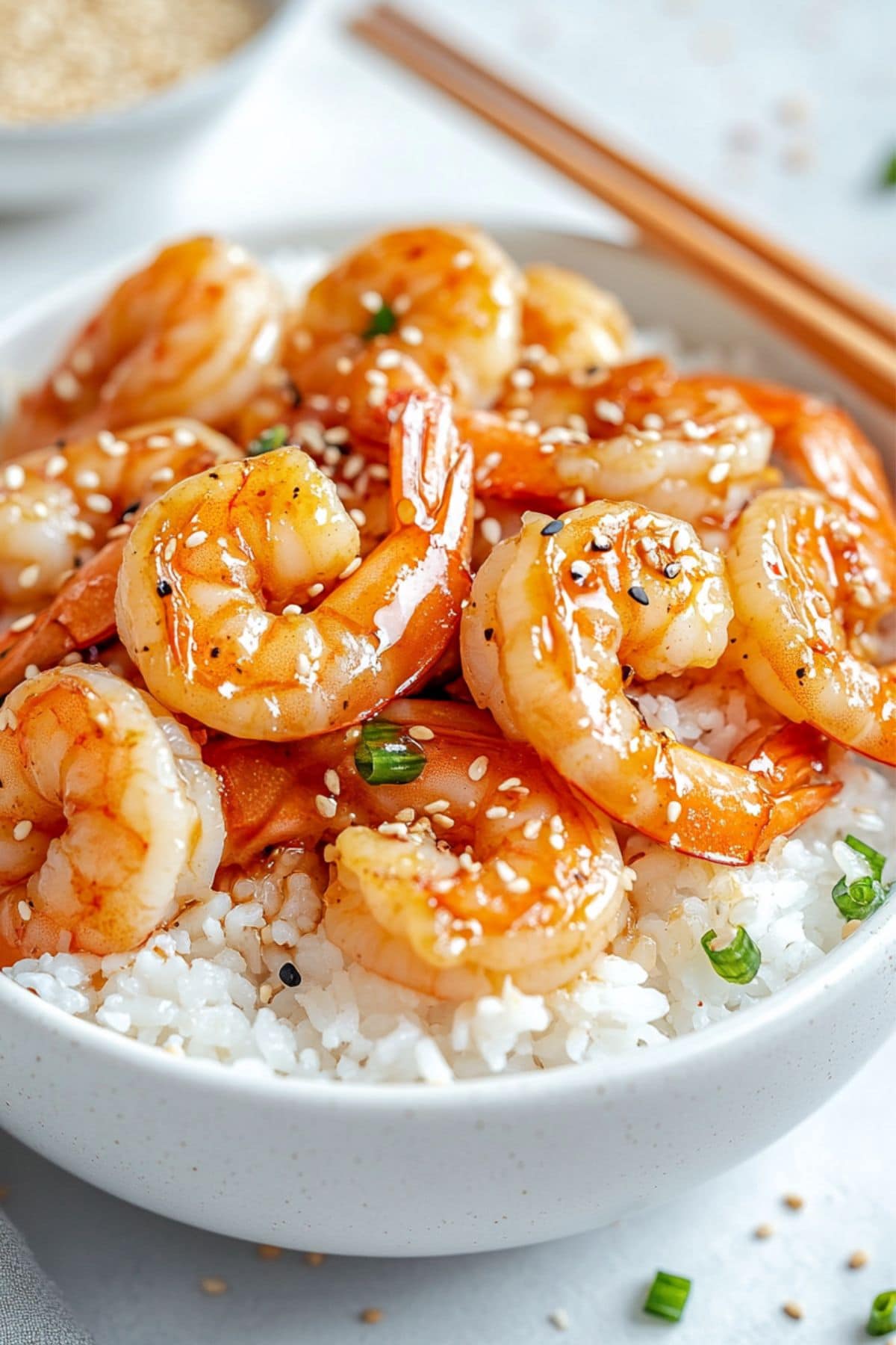 Hibachi shrimp served on top of white rice in a white bowl.