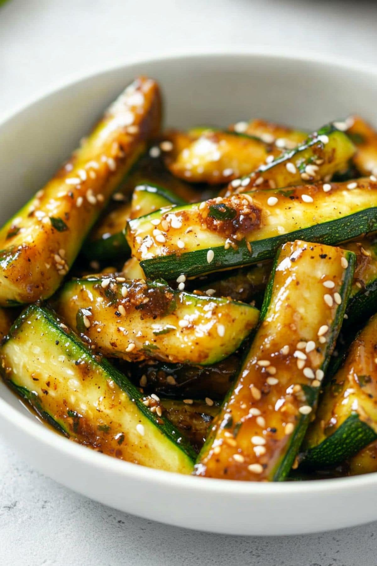 Hibachi zucchini tossed in umami sauce garnished with sesame seeds.