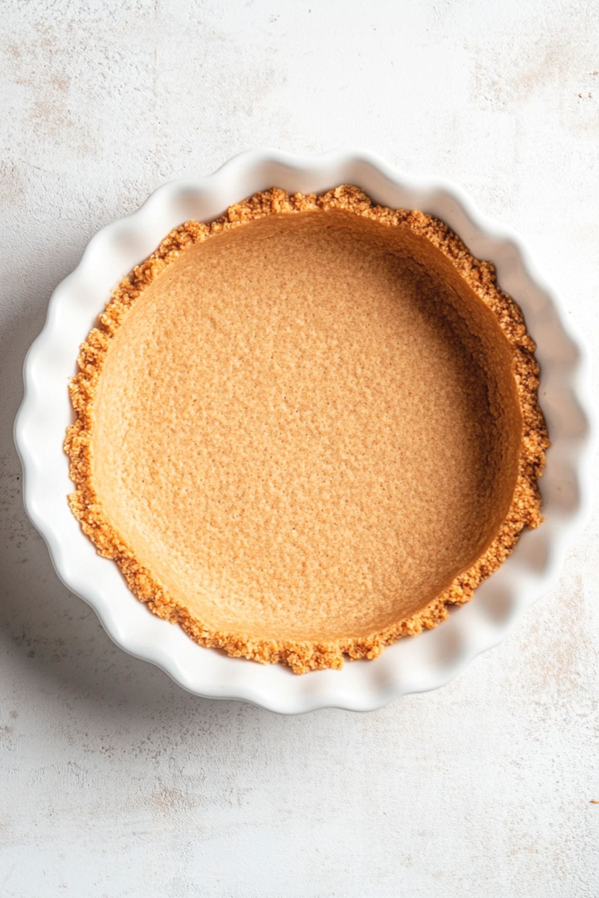 Graham crust in a white pie dish, top view