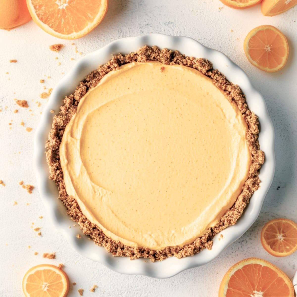 Whole orange creamsicle pie in a white baking dish.