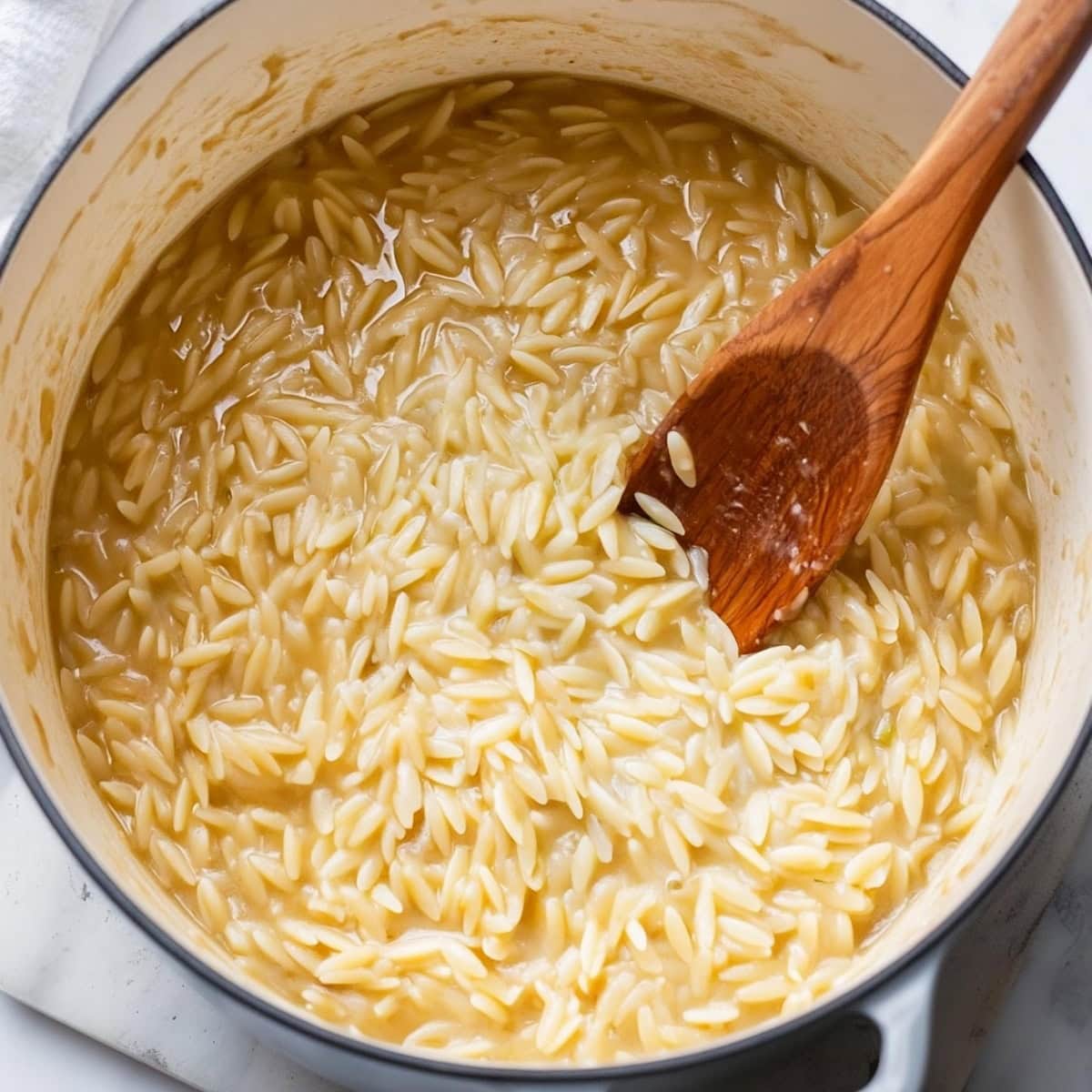 Close-up of orzo risotto in a large pan.