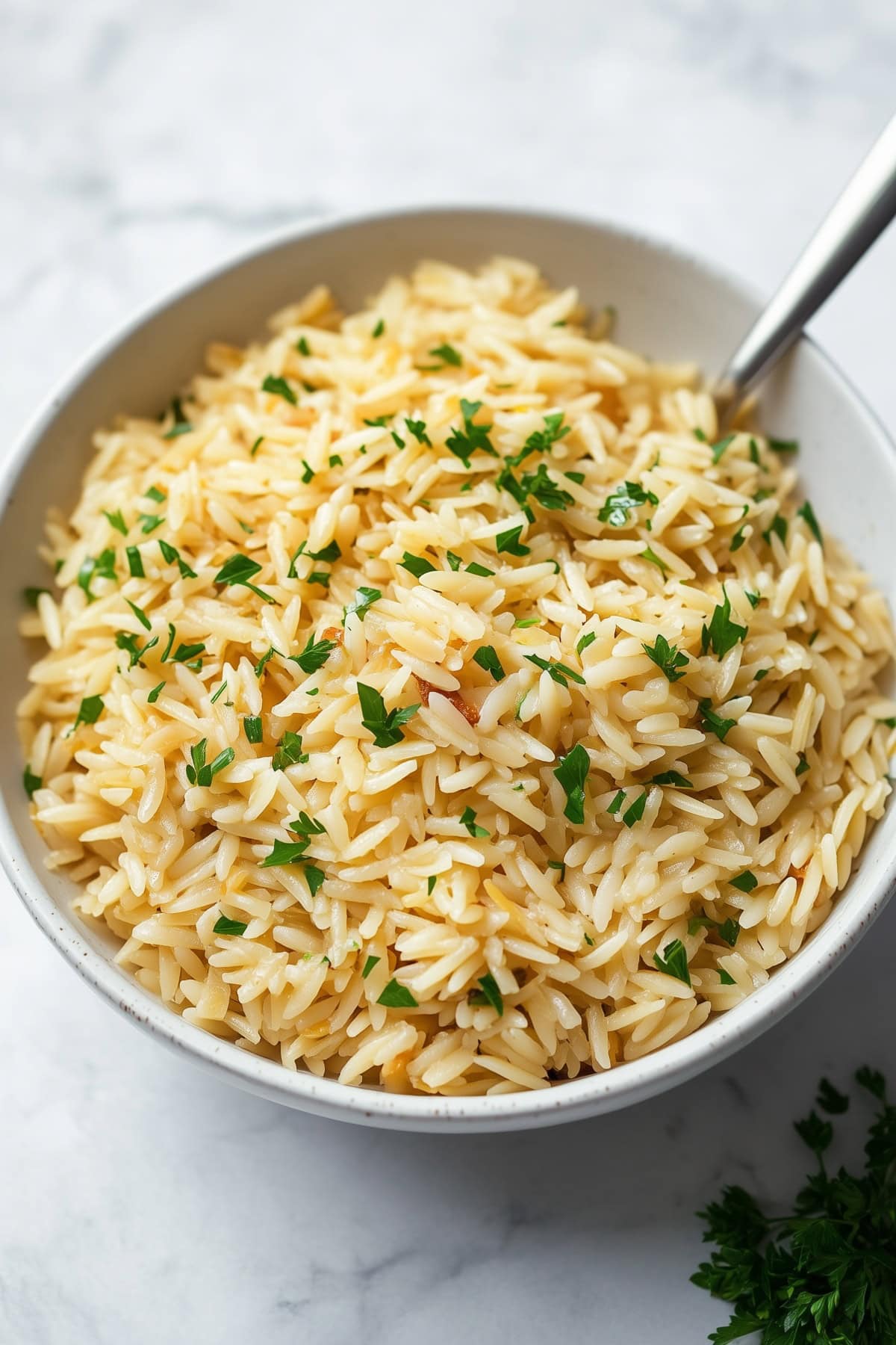 Fluffy rice pilaf served in a bowl, garnished with fresh parsley.