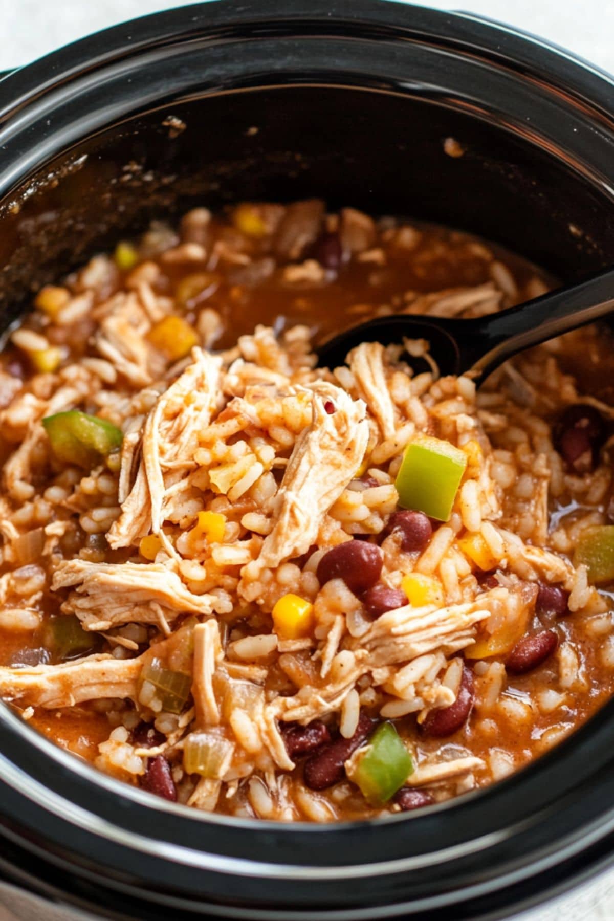 Chicken burritos filling in a slow cooker pot.