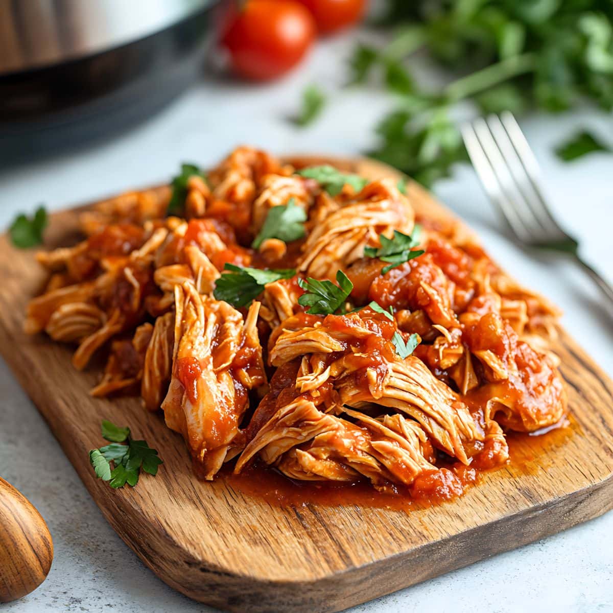 Shredded chicken in  a wooden board.