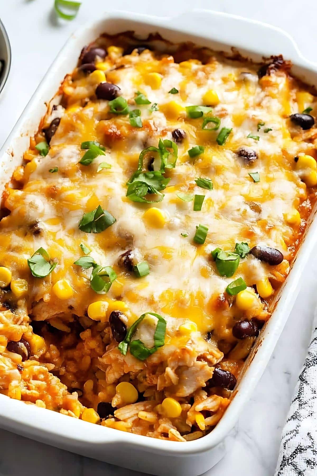 Southwest chicken casserole with melted cheese, corn, black beans, rice and chicken chunks.