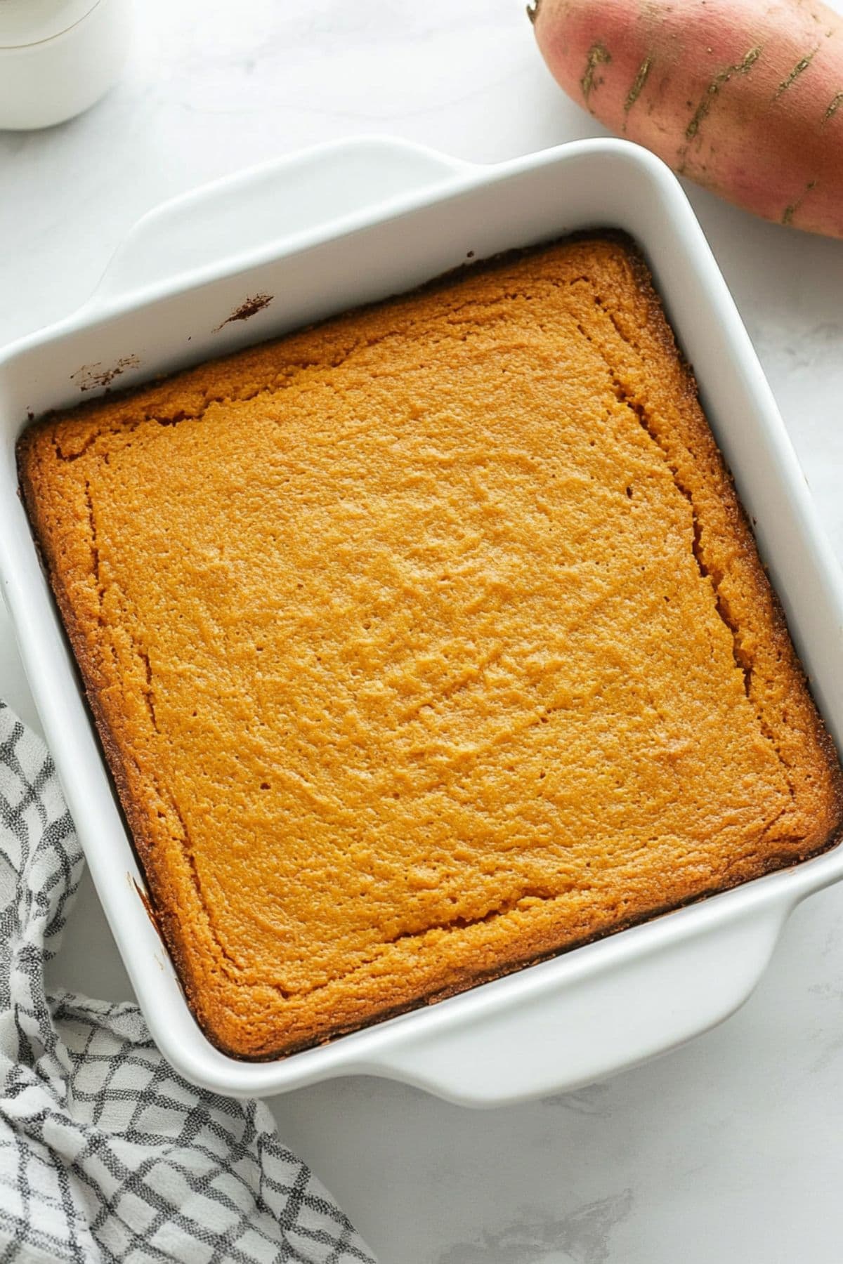 Sweet potato cornbread in a square white baking dish, top view