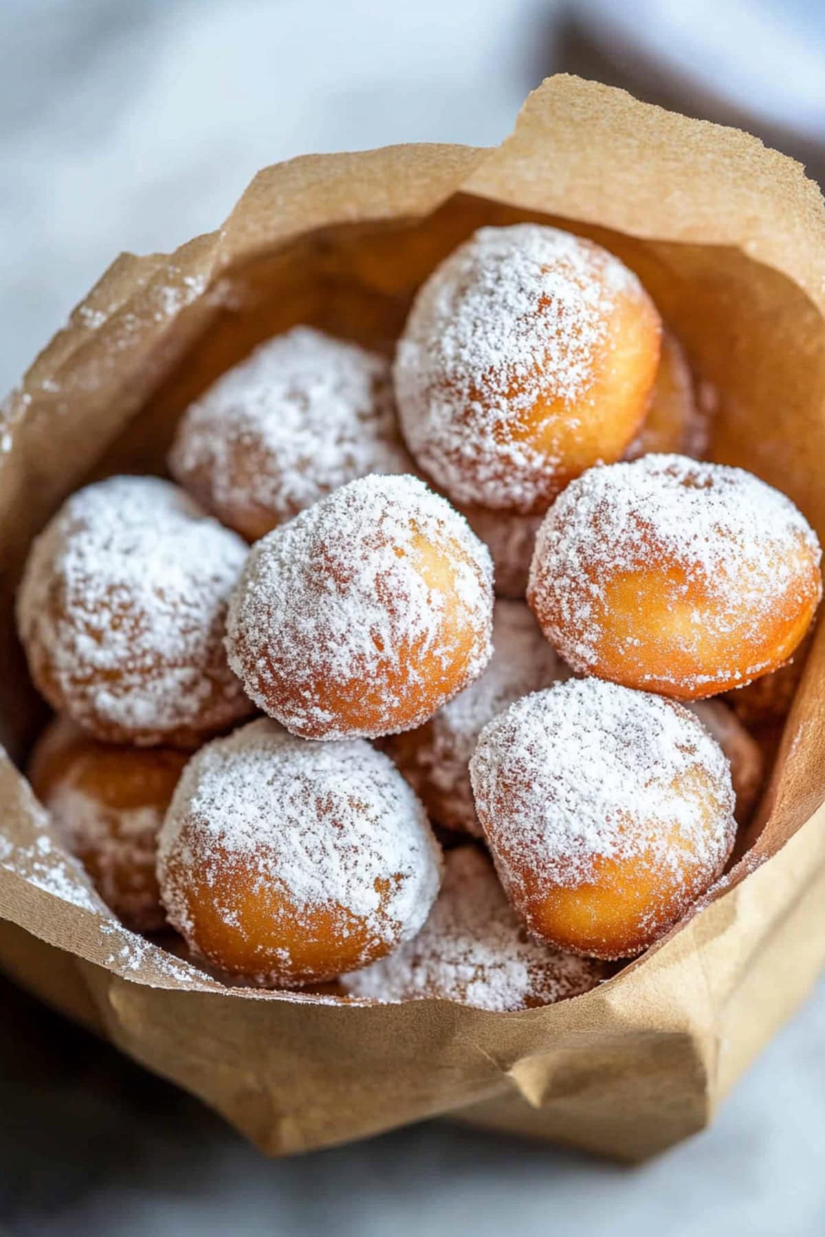 Paper filled with Zeppole dusted with powdered sugar