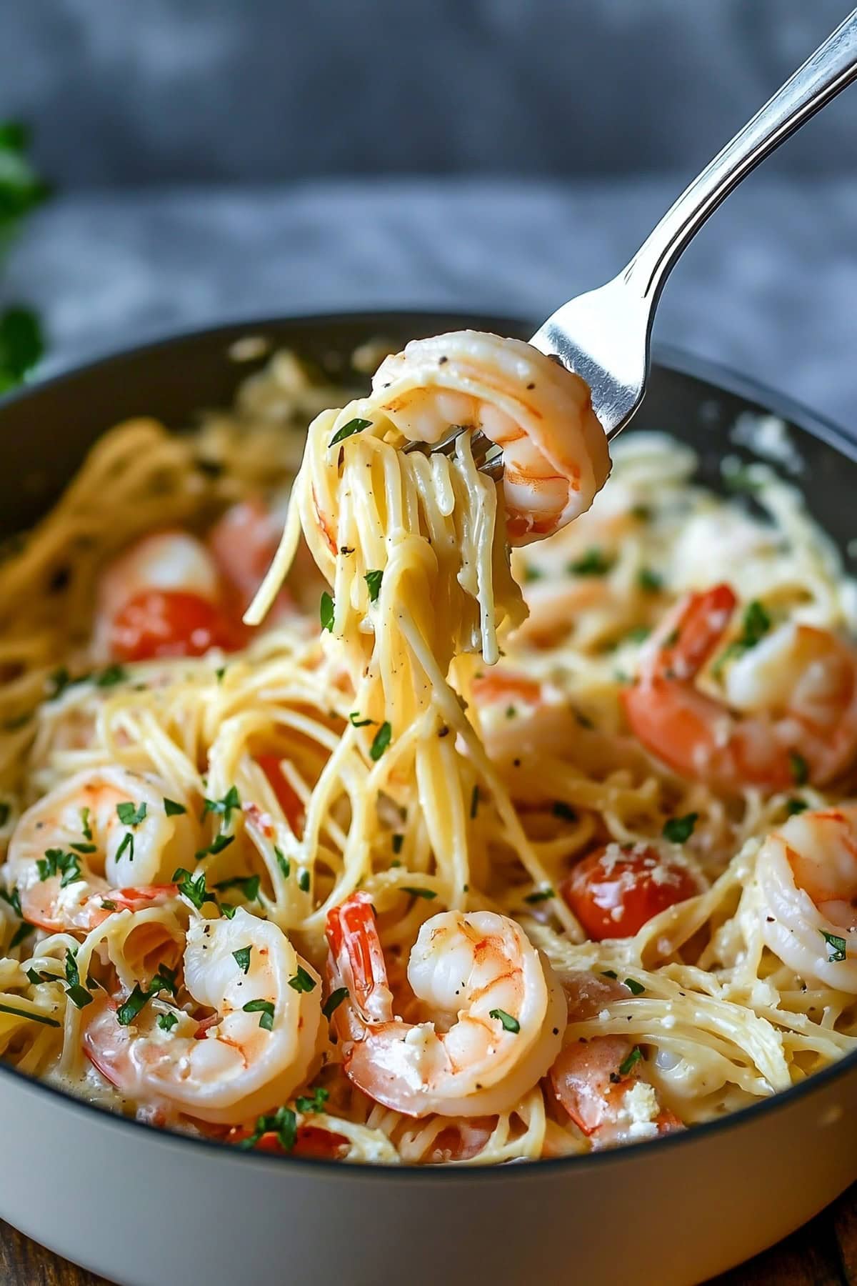 Creamy angel hari pasta with shrimp served in a bowl lifted with fork. 