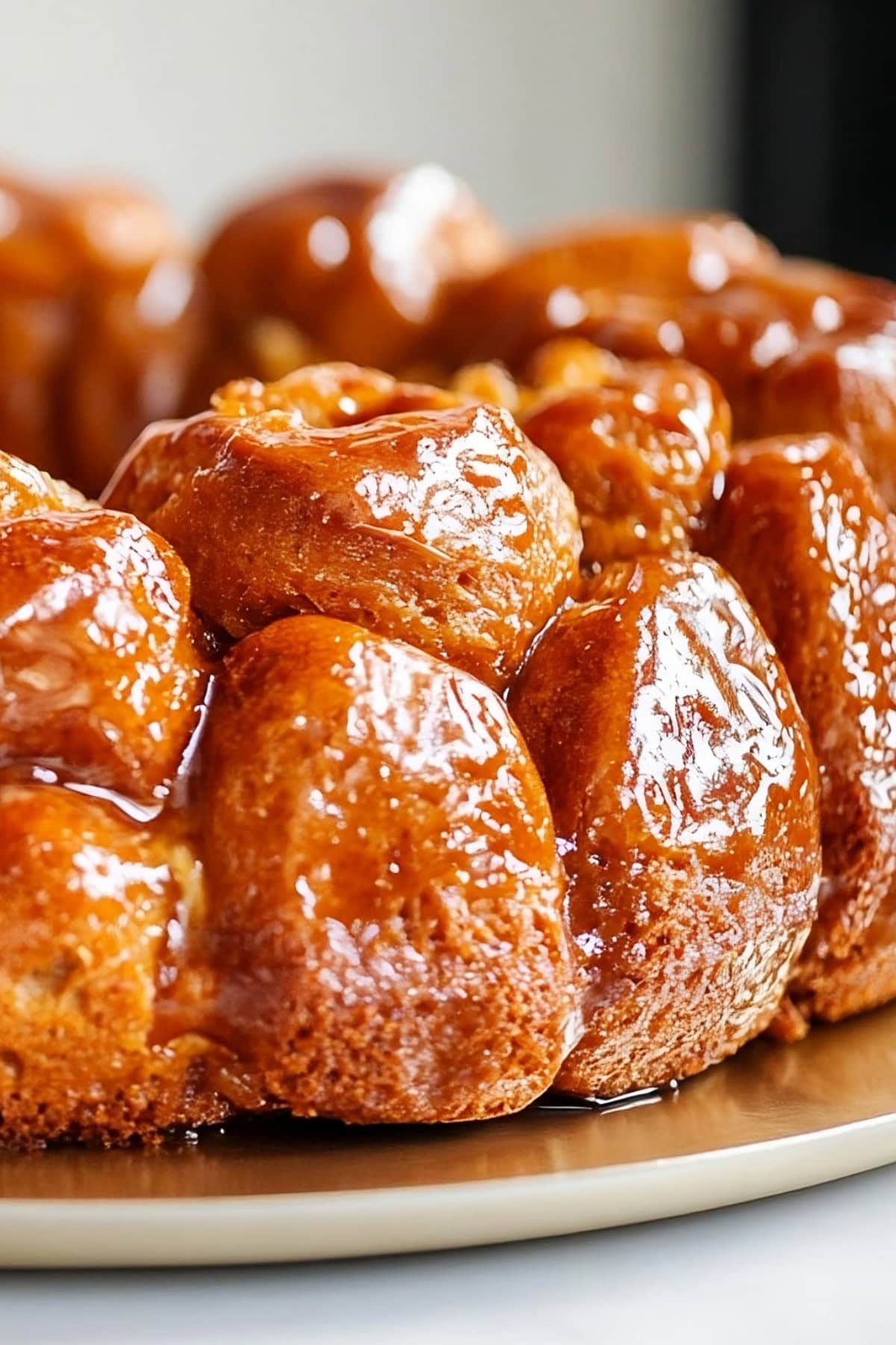 Monkey bread with biscuits on cake tray drizzled with sugar syrup, close up side view.