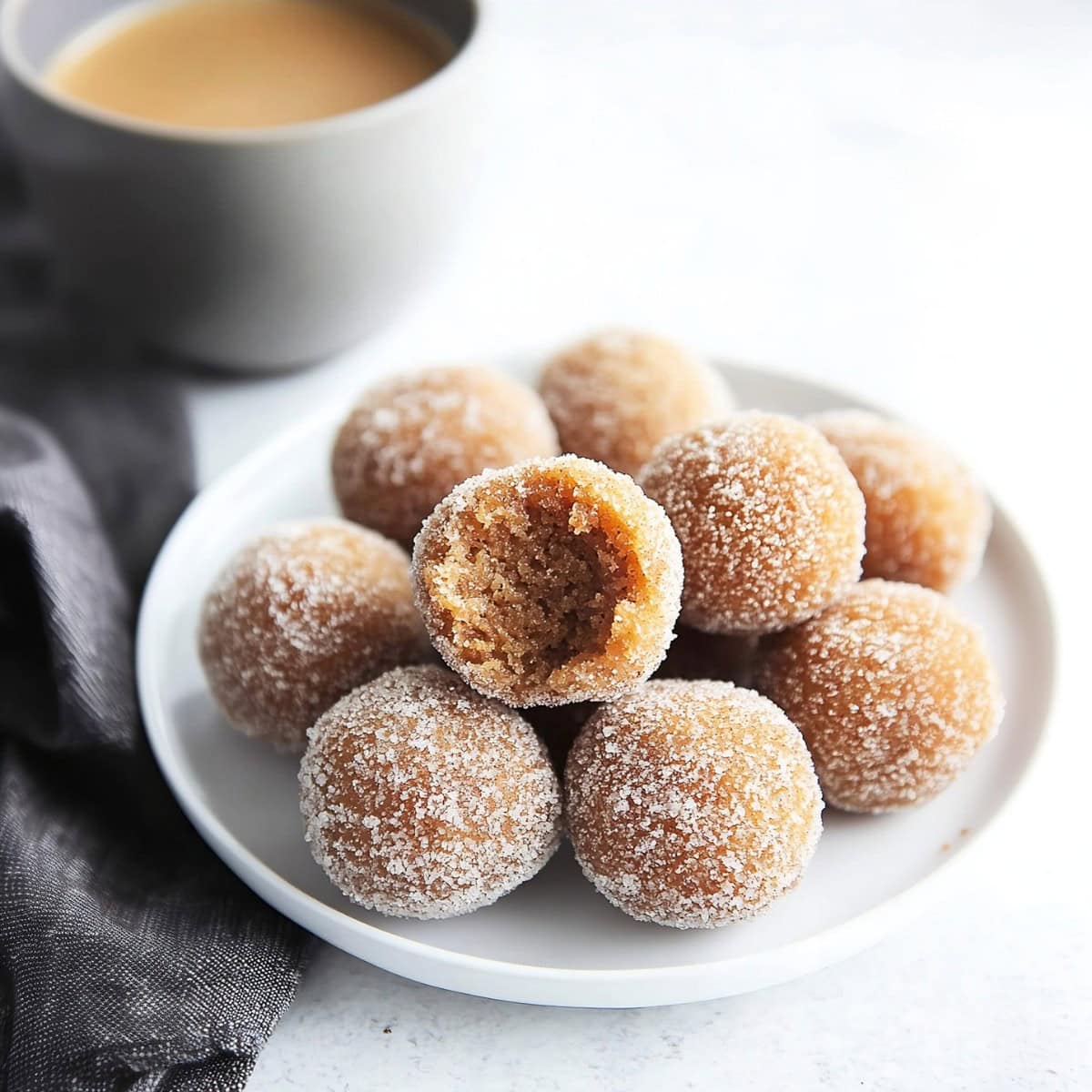 Pumpkin Spiced Donut holes on a plate, one has a bite taken out of it