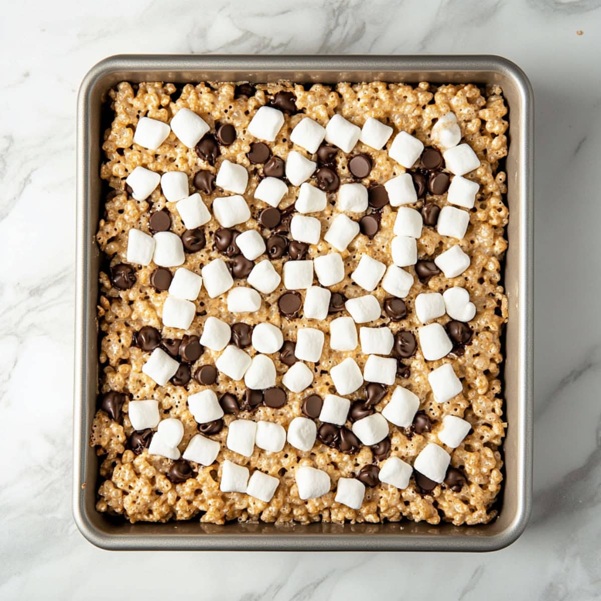 Avalanche bars in a baking dish topped with mini marshmallows and mini chocolate chips.