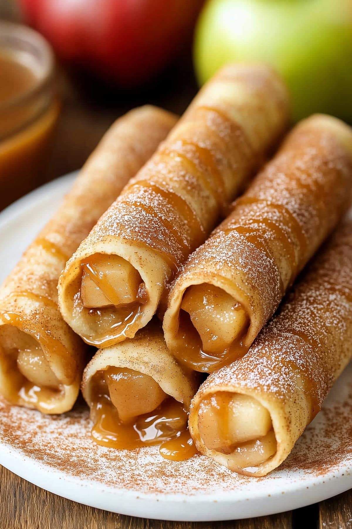 A stack of homemade caramel apple taquitos in a white plate.